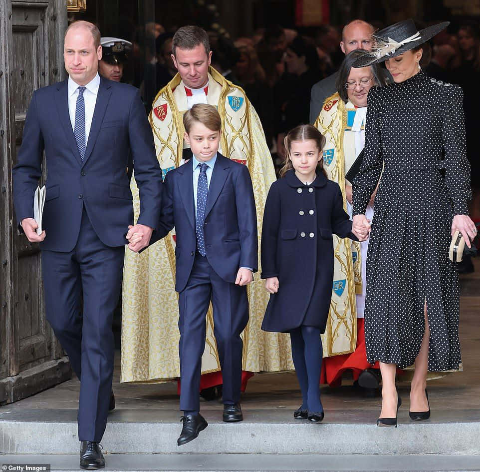 Prinsen og hertuginden af Cambridge og deres børn går ned ad gaden.
