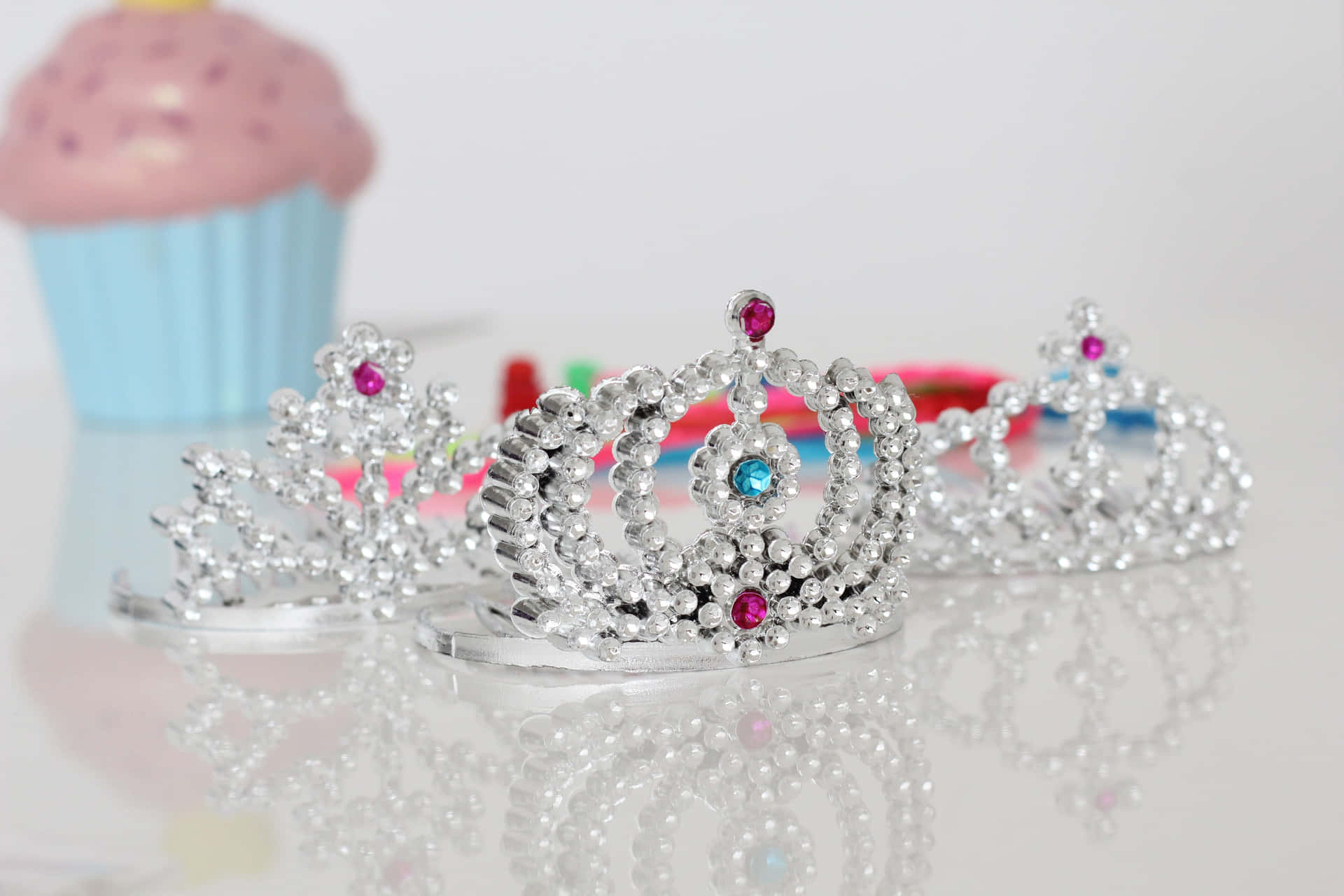 A Set Of Tiaras And Cupcakes On A Table Wallpaper