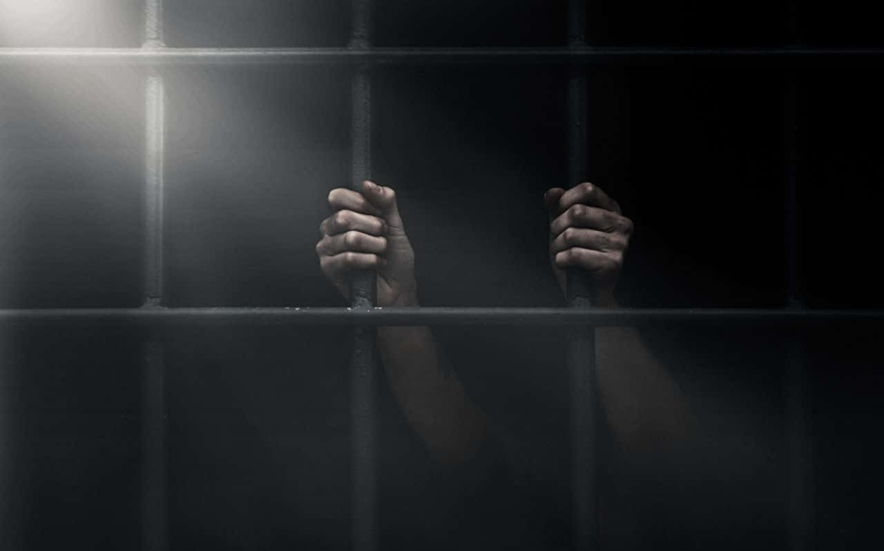 Lasmanos Del Prisionero En La Celda De La Cárcel