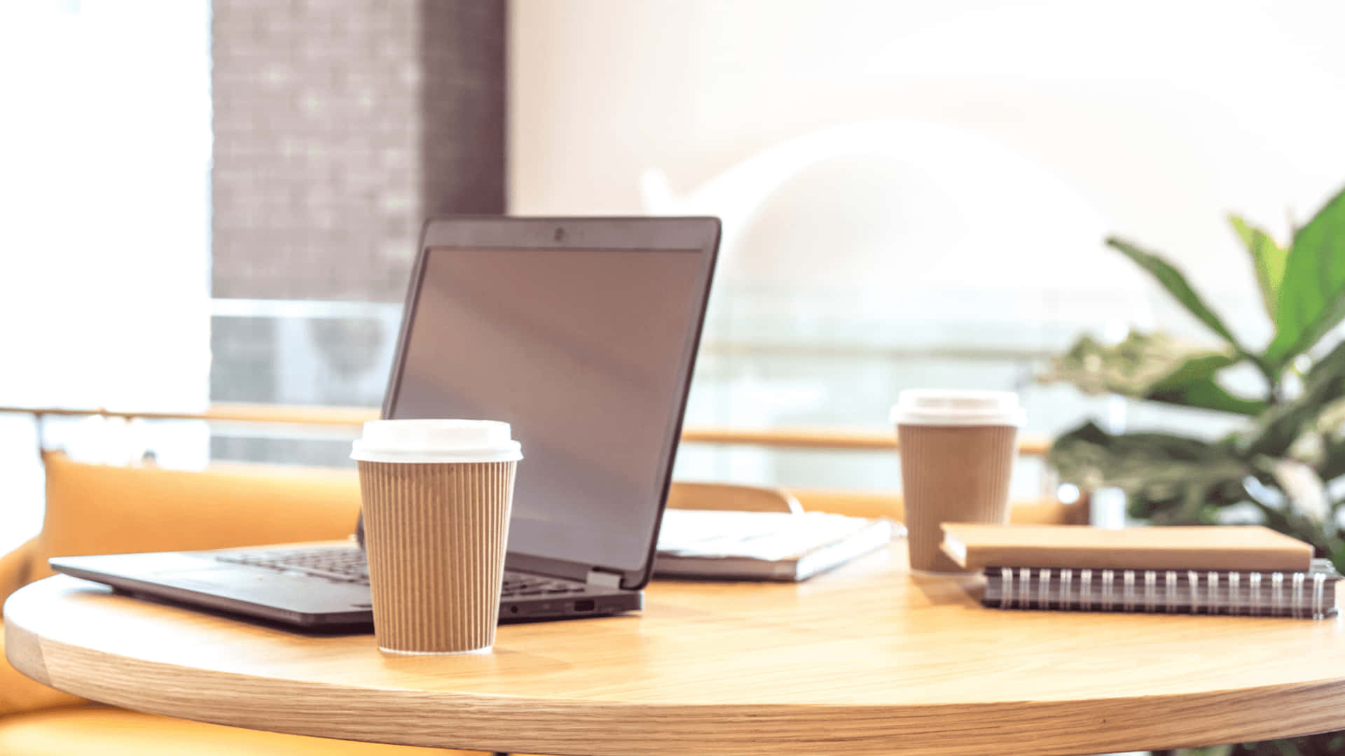 En bærbar computer og en kop kaffe på et bord.