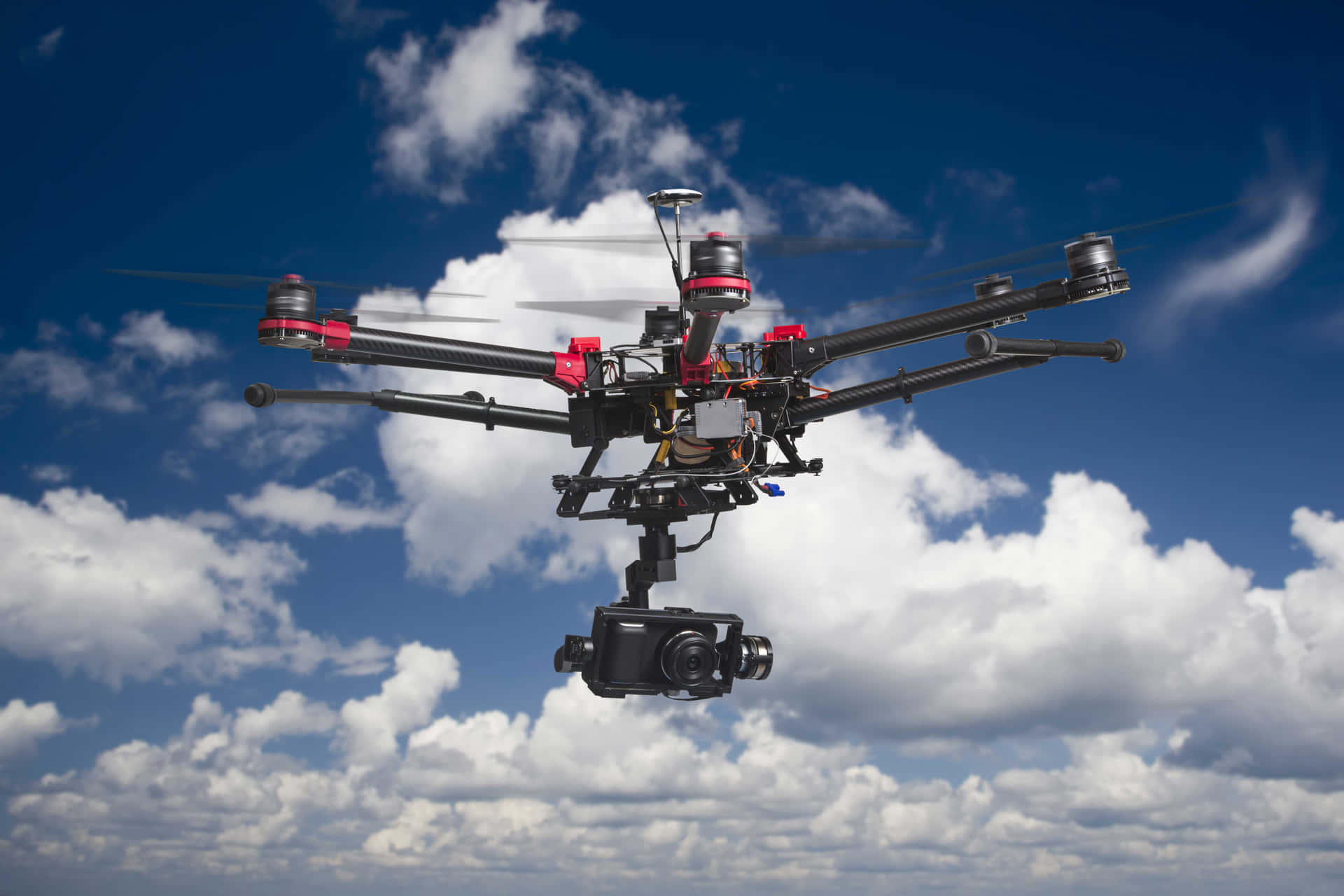 Professional Drone In Flight Against Cloudy Sky Wallpaper