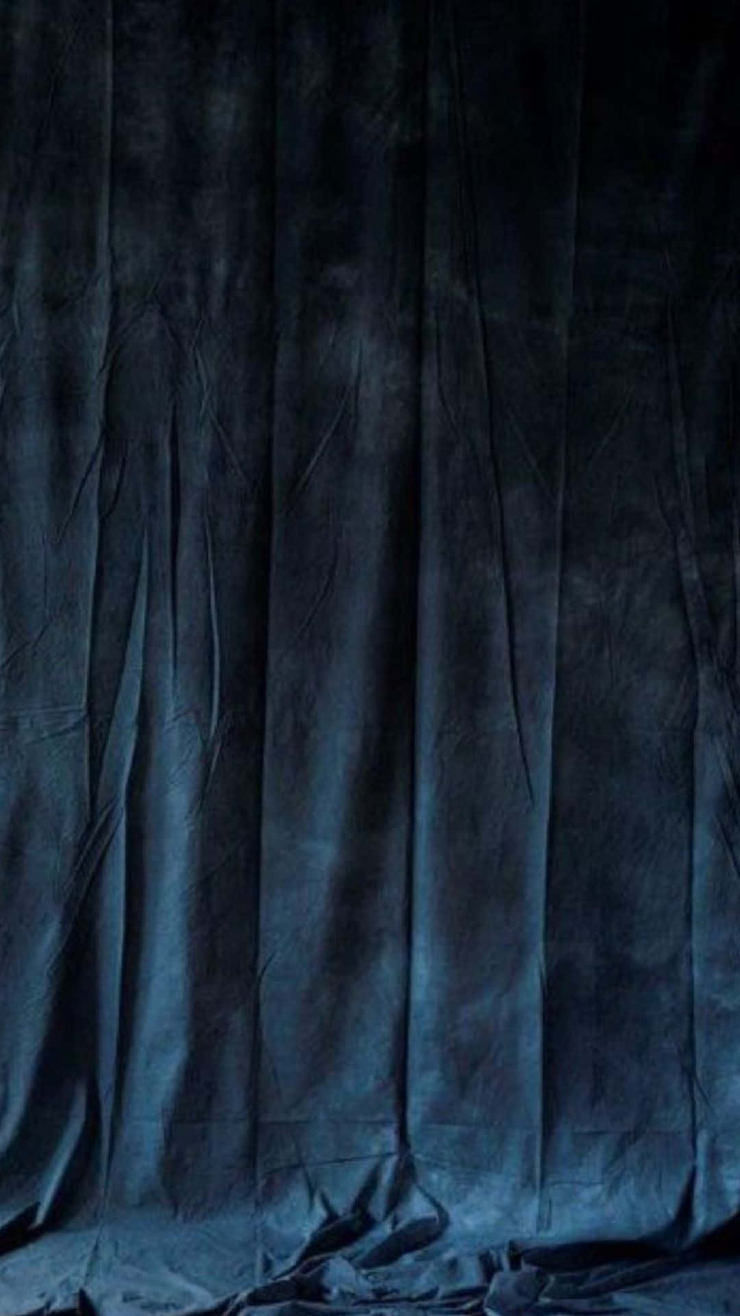 A Dark Blue Cloth Is Draped Over A Black Background