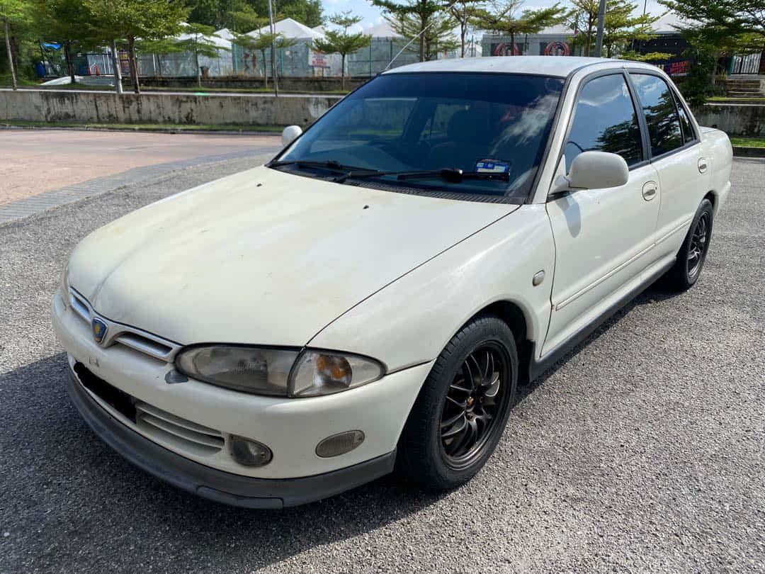 Proton Wira Witte Sedan Geparkeerd Buiten Achtergrond