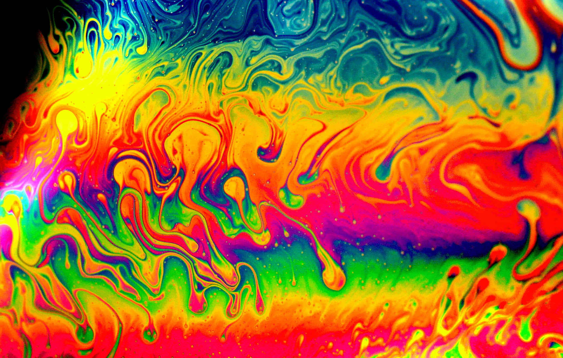 Psychedelic colors merge together in a mesmerizing display Wallpaper