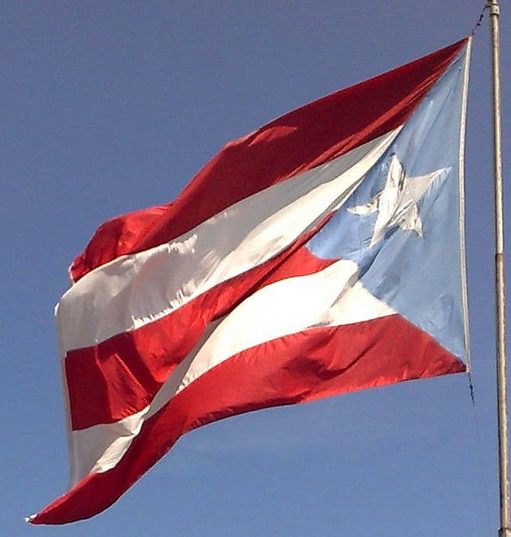 Puerto Rico Flag Waving Against Blue Sky Wallpaper