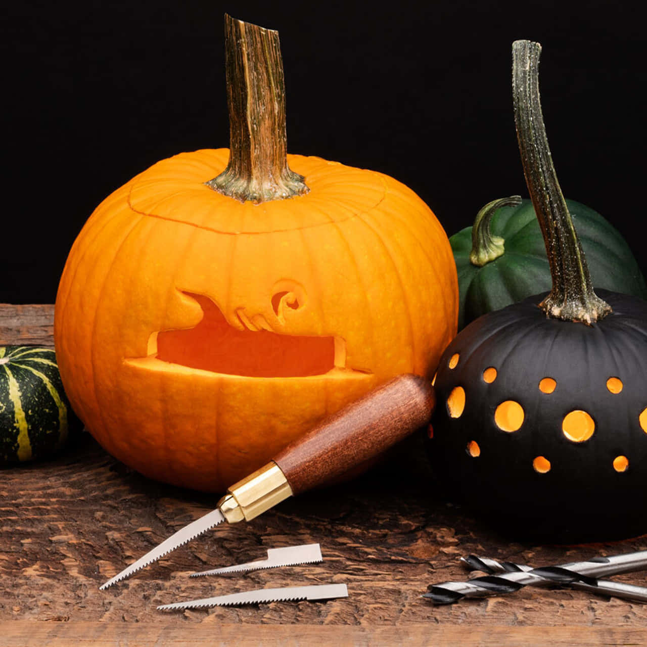 A Group Of Pumpkins With Carving Tools On A Table