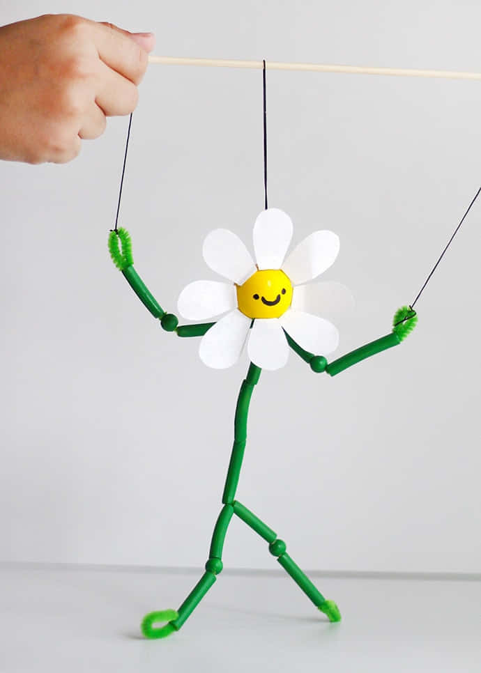 A Person Holding A Flower Puppet On A String