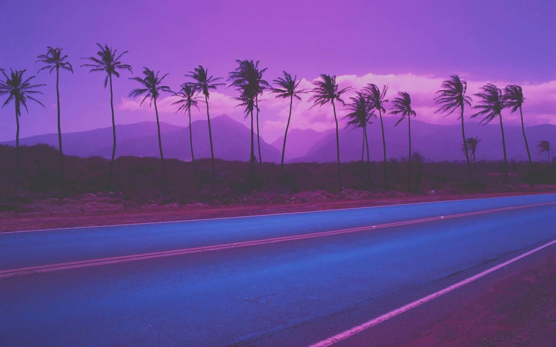 A Purple Road With Palm Trees And Mountains Wallpaper
