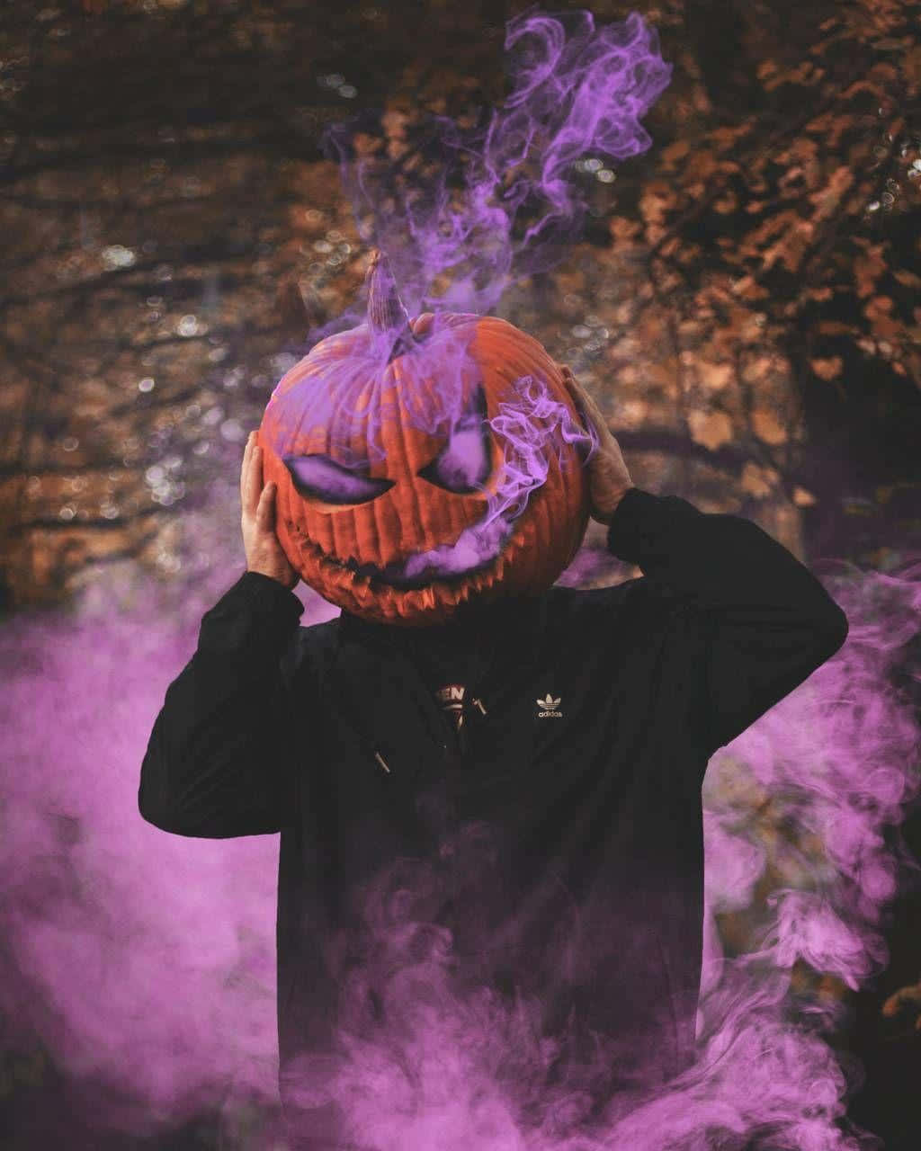 A Man With A Purple Pumpkin Mask And Smoke Wallpaper