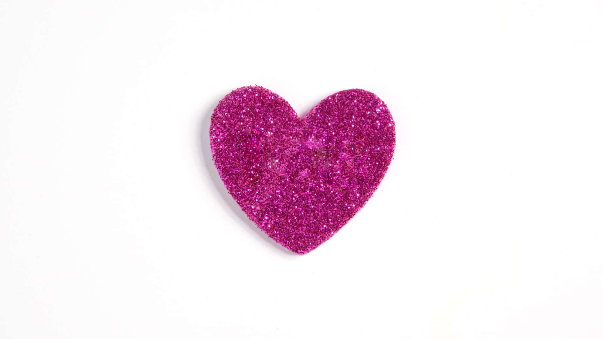 A Pink Glitter Heart Shaped Sticker On A White Background