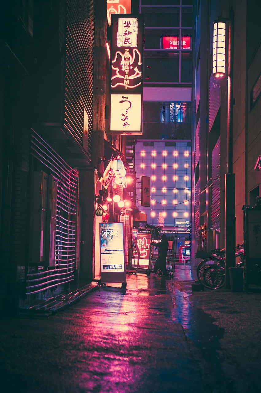A City Street At Night With Neon Signs Wallpaper
