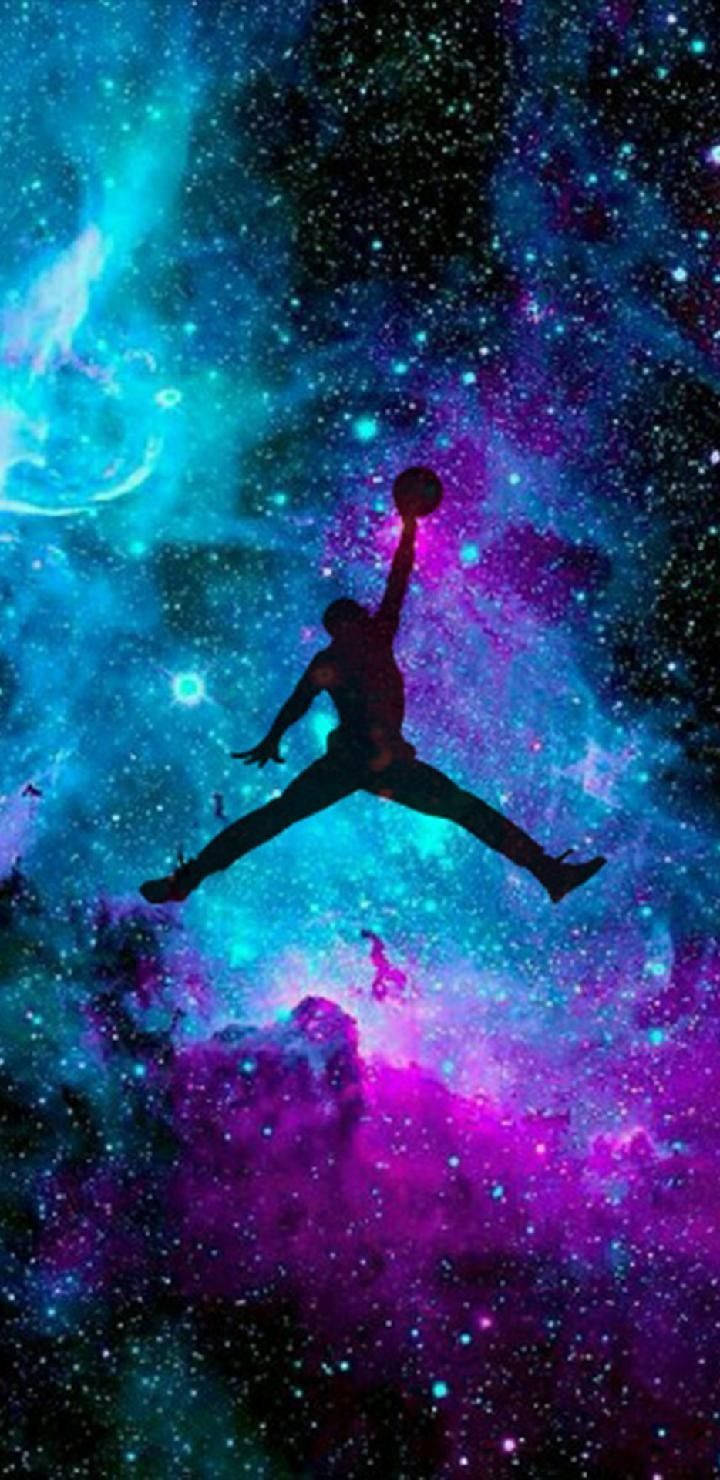 En mand hopper i luften i et galaksmiljø Wallpaper