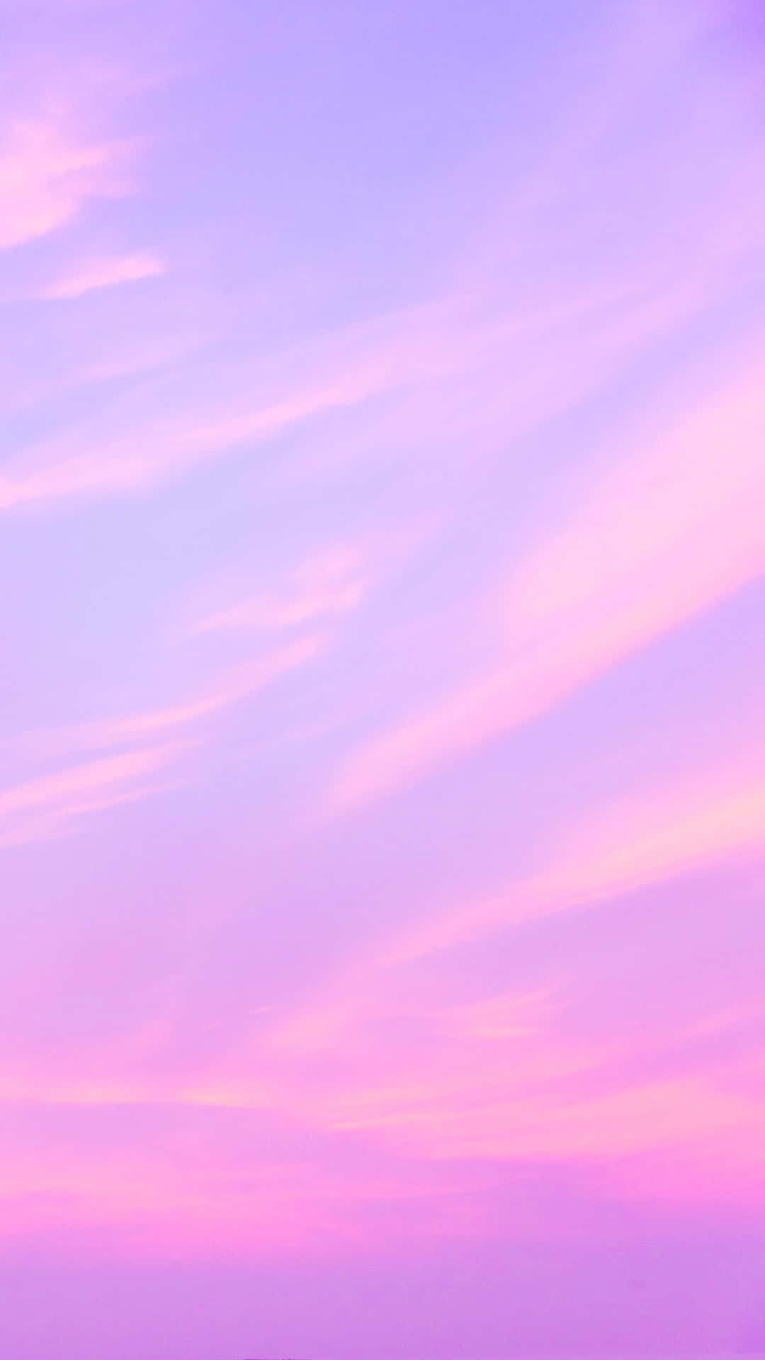 Et lyserødt og lilla himmel med skyer Wallpaper