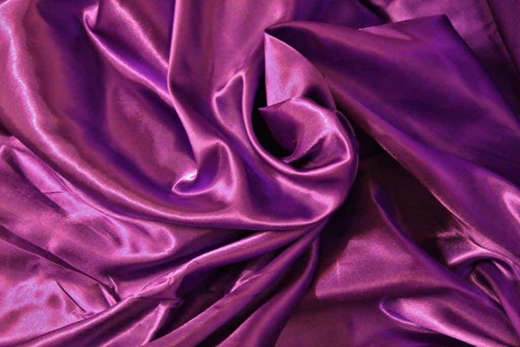 An elegant bedroom featuring a rich purple satin bedspread Wallpaper