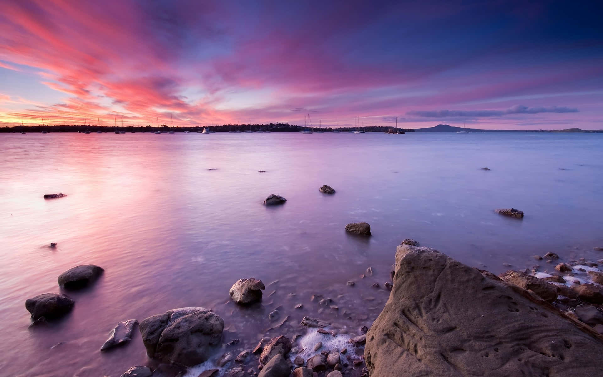 A Stunning Purple Sunset Over a Calm Ocean Wallpaper