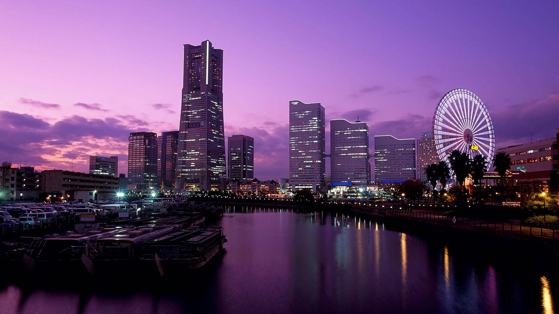 Witness the breathtaking beauty of a purple sunset cityscape. Wallpaper