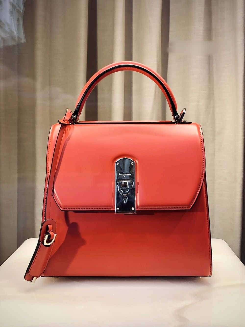 A Red Handbag On Display In A Window