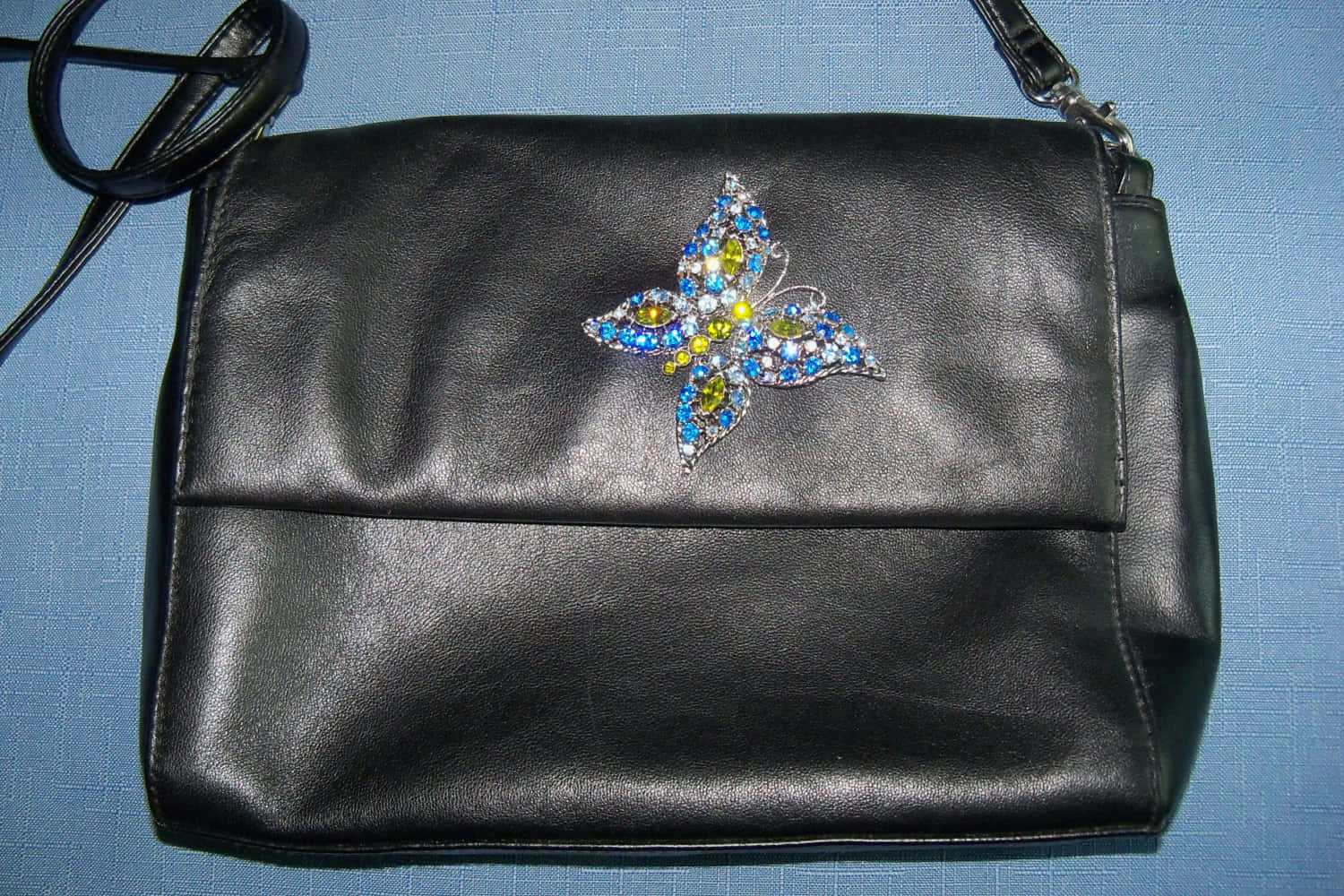 a black purse with a butterfly on it