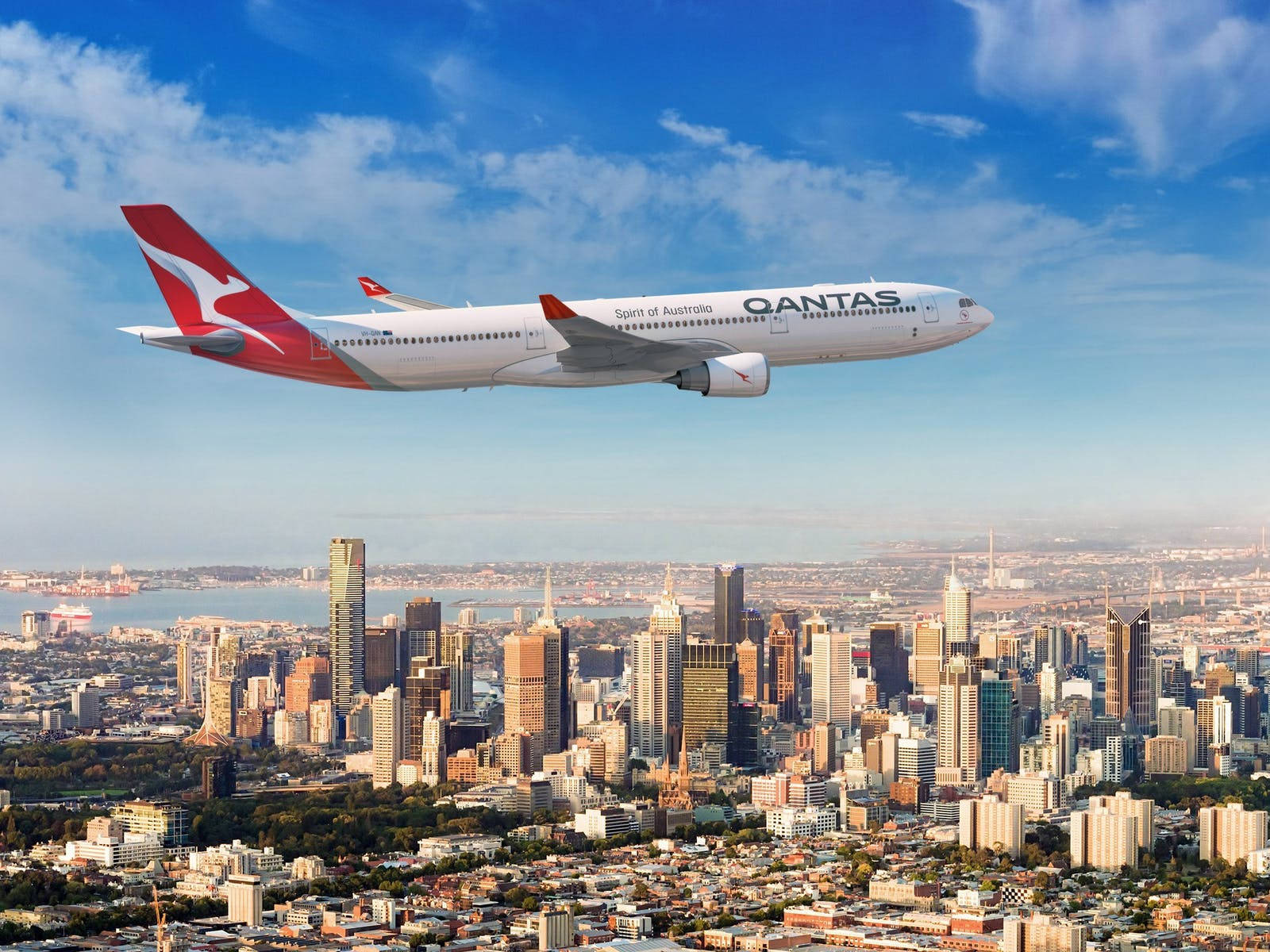 Aviónde Pasajeros De Qantas Sobre La Ciudad. Fondo de pantalla