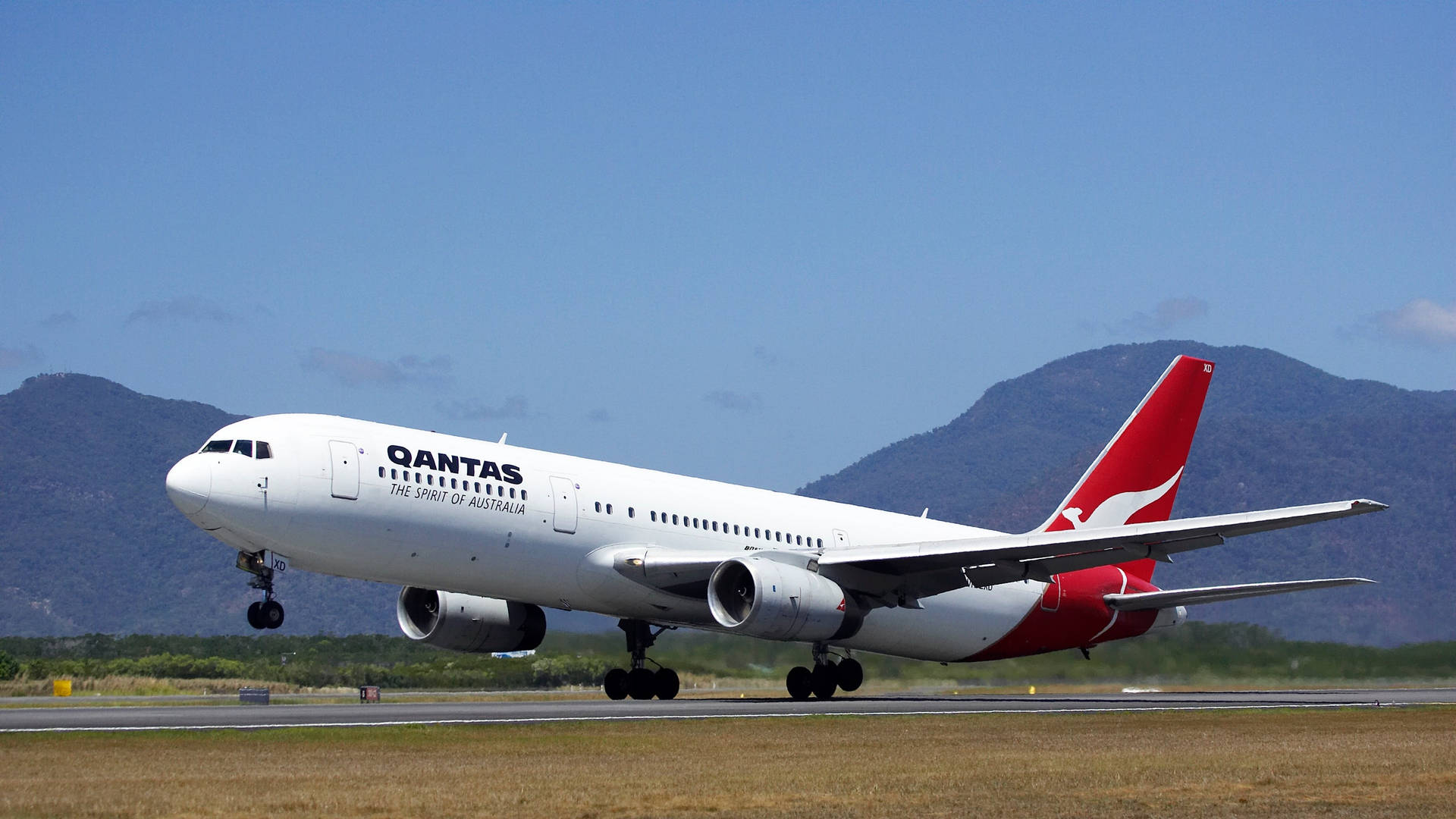 Aeroplanopasseggeri Qantas In Decollo Sfondo