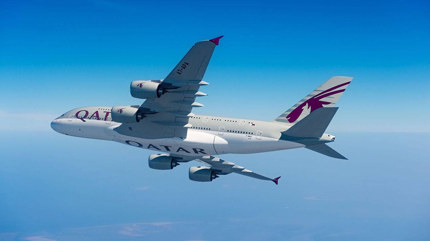 Qatar Airways flyvemaskine, der skærer den blå himmel i to Wallpaper