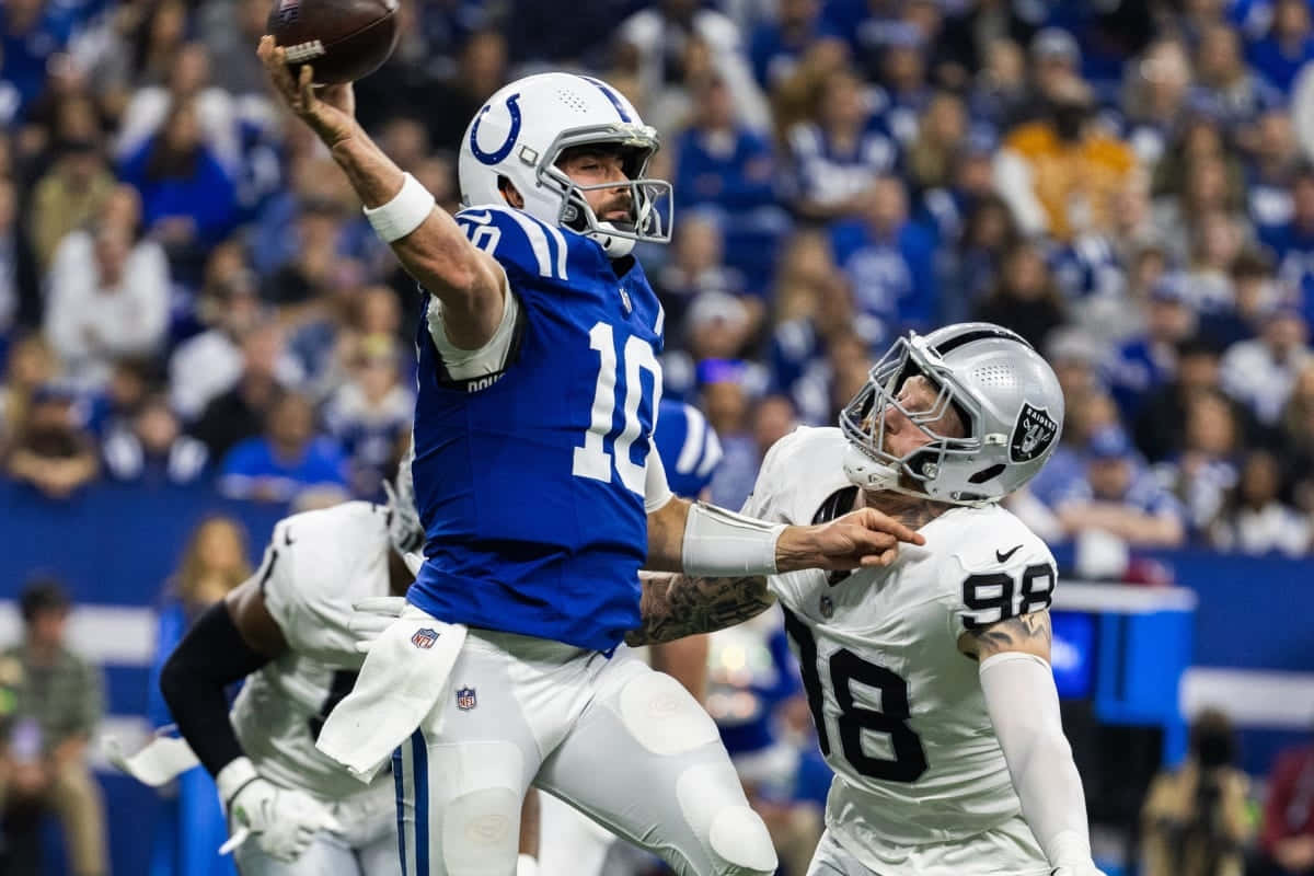 Quarterback Throwing Football During Game Wallpaper