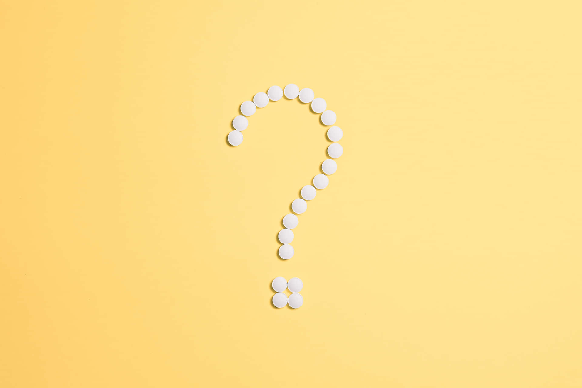 A Question Mark Made Of Pills On A Yellow Background