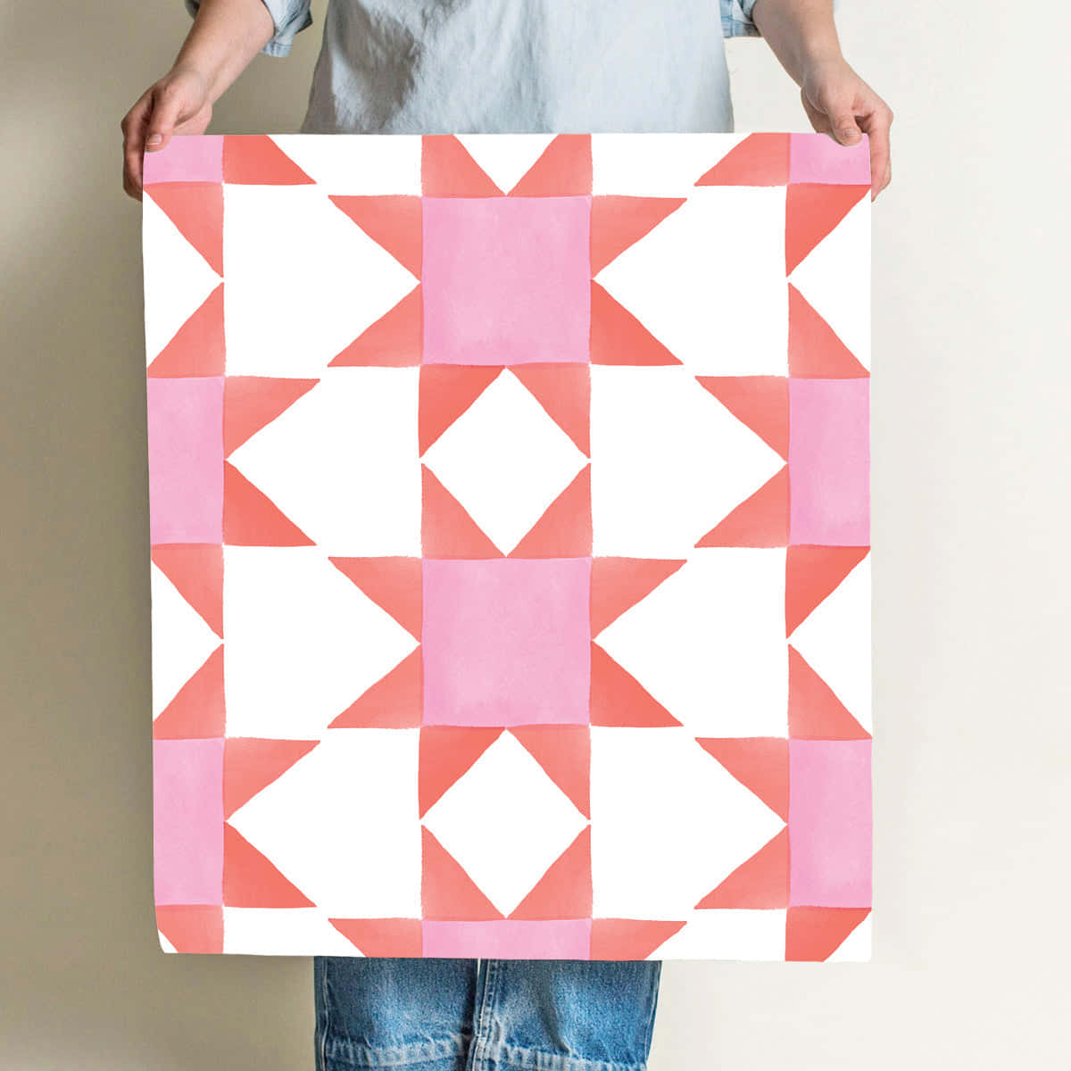 A Woman Holding Up A Pink And White Quilt Wallpaper