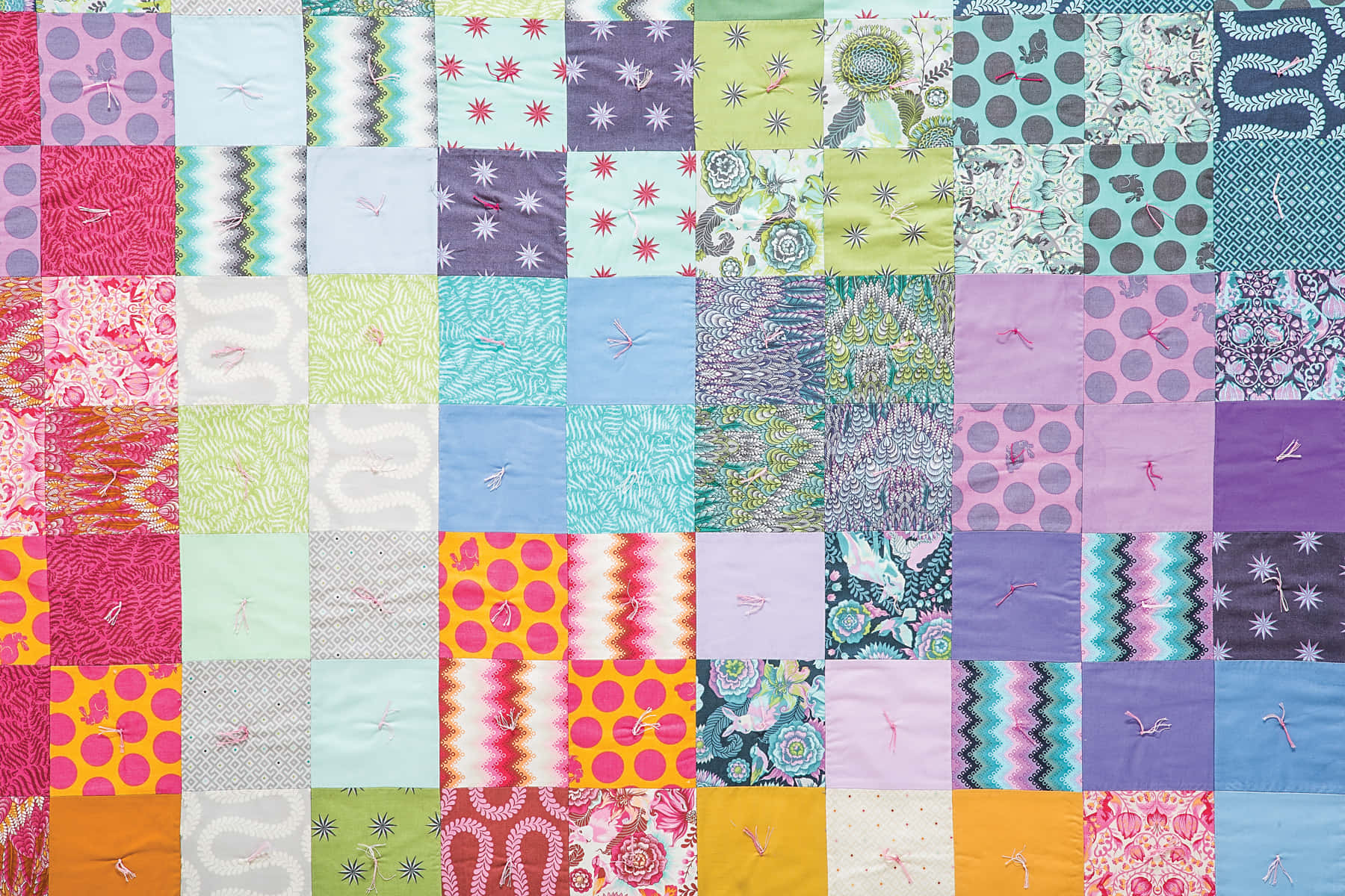 A Colorful Quilt With Many Different Colors Wallpaper