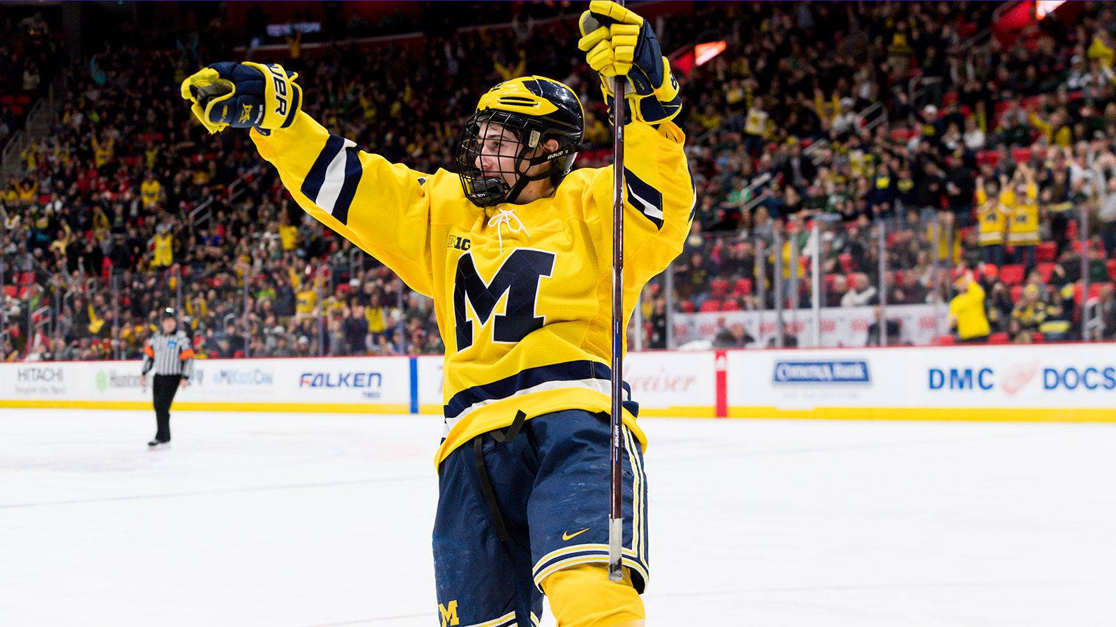 Quinn Hughes Looking To The Left Holding Hockey Stick And With Both Arms In The Air Wallpaper