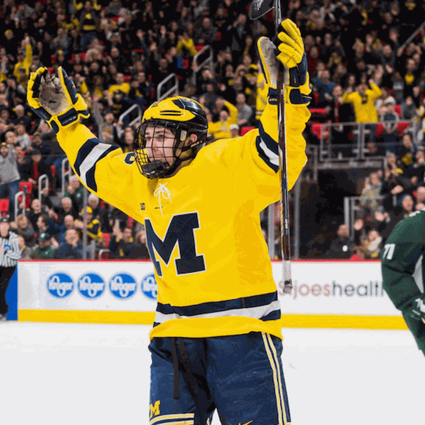 Quinn Hughes With Both Hands In The Air And Holding Hockey Stick Wallpaper