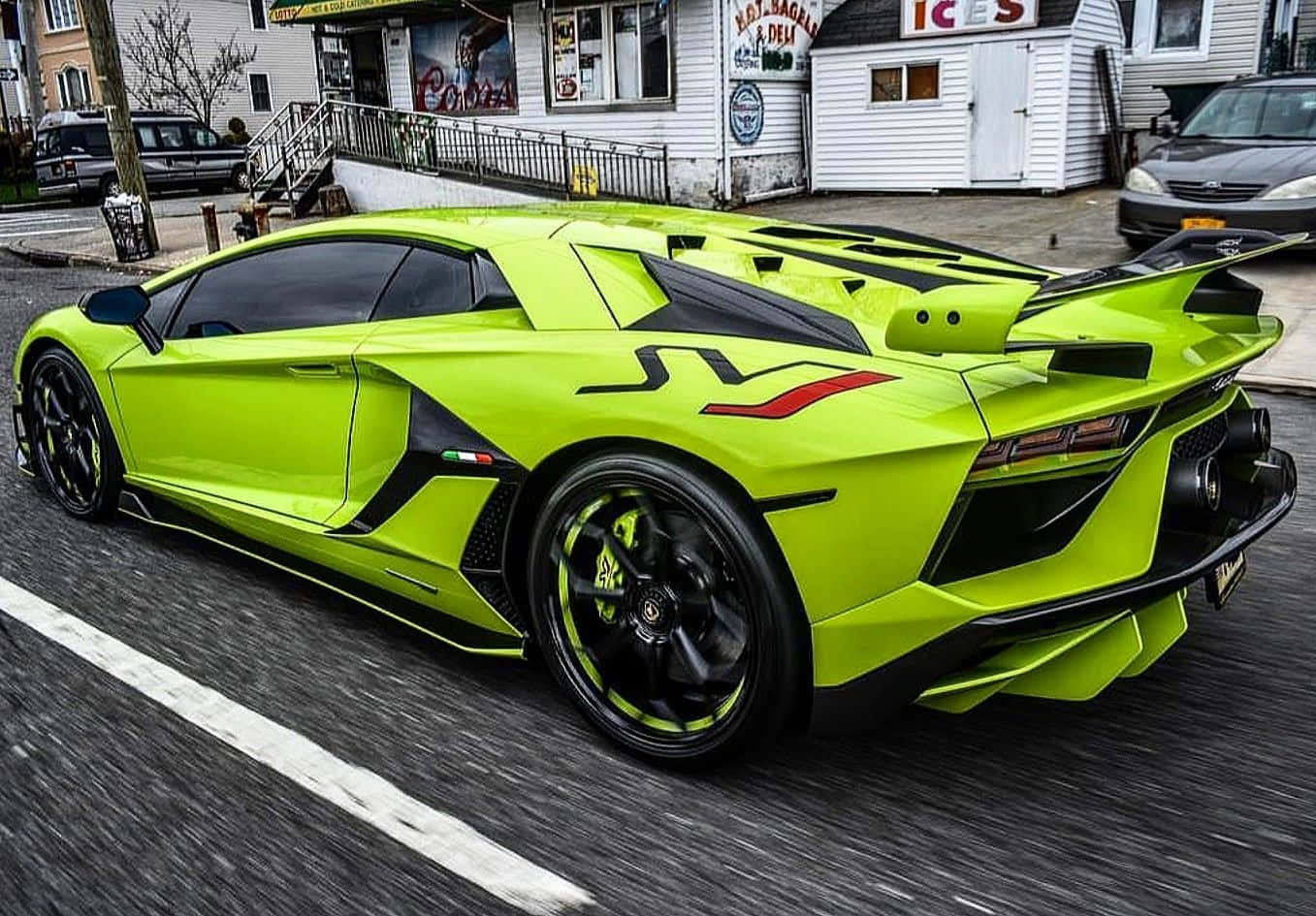 A Green Sports Car Is Driving Down The Street
