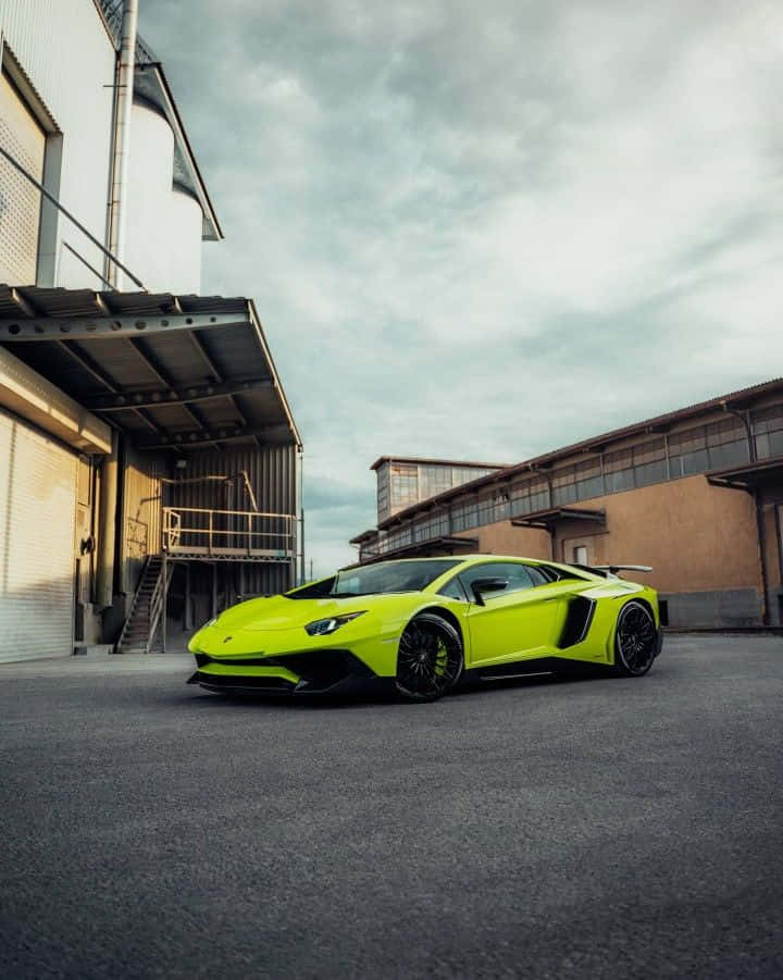 A Green Lamborghini Parked In Front Of An Industrial Building