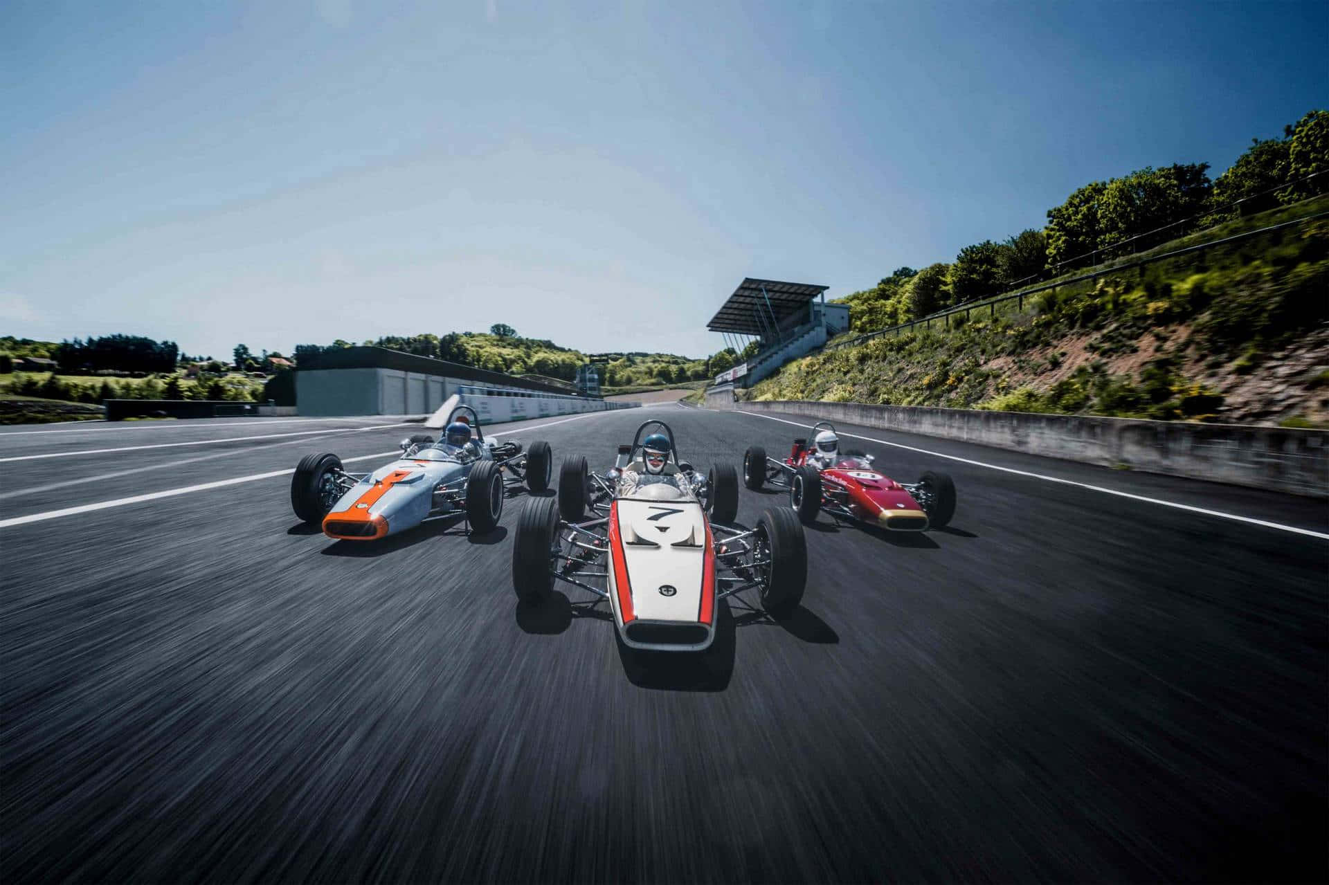 A Group Of Racing Cars On A Track