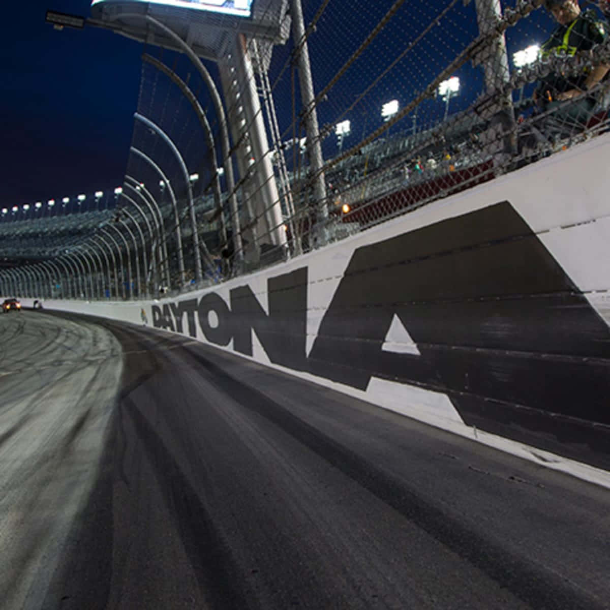 A Race Car Driving Down A Track At Night