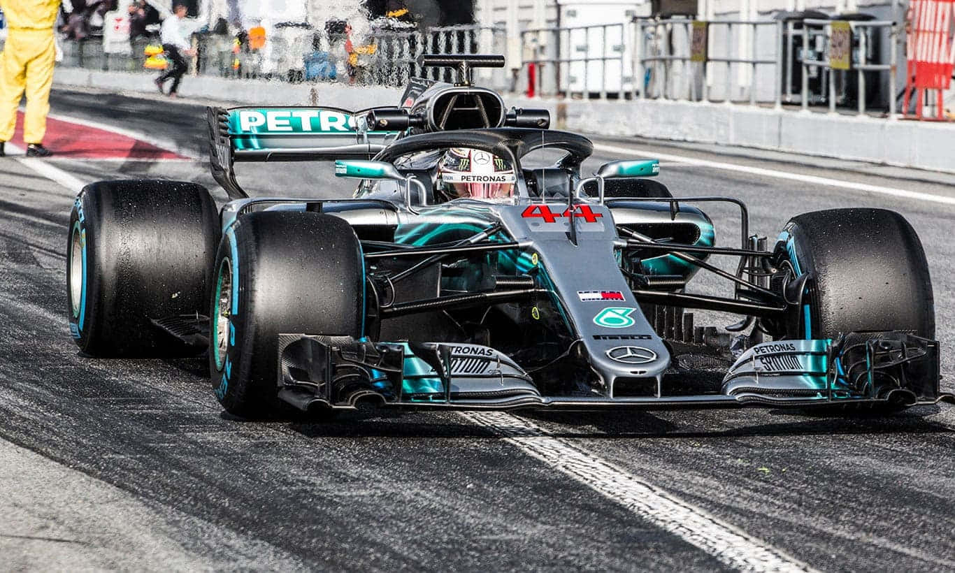 A Mercedes F1 Car Driving Down The Track