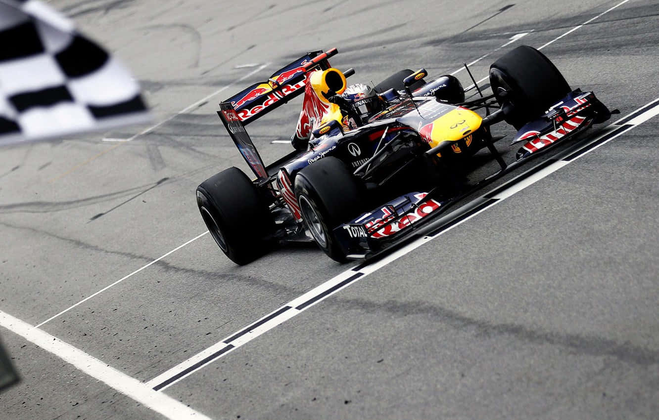 A Red Bull Racing Car Is Racing Down The Track