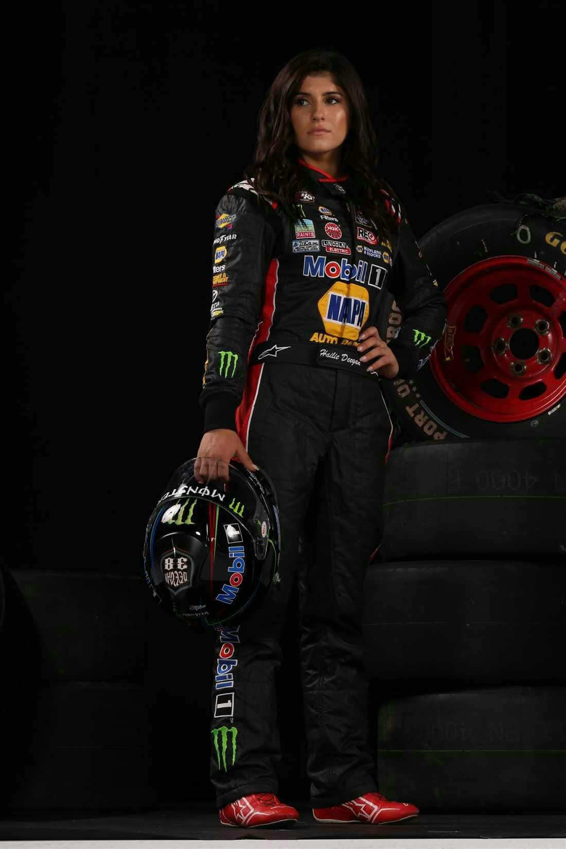 Racing Driver Portraitwith Helmetand Tires Wallpaper