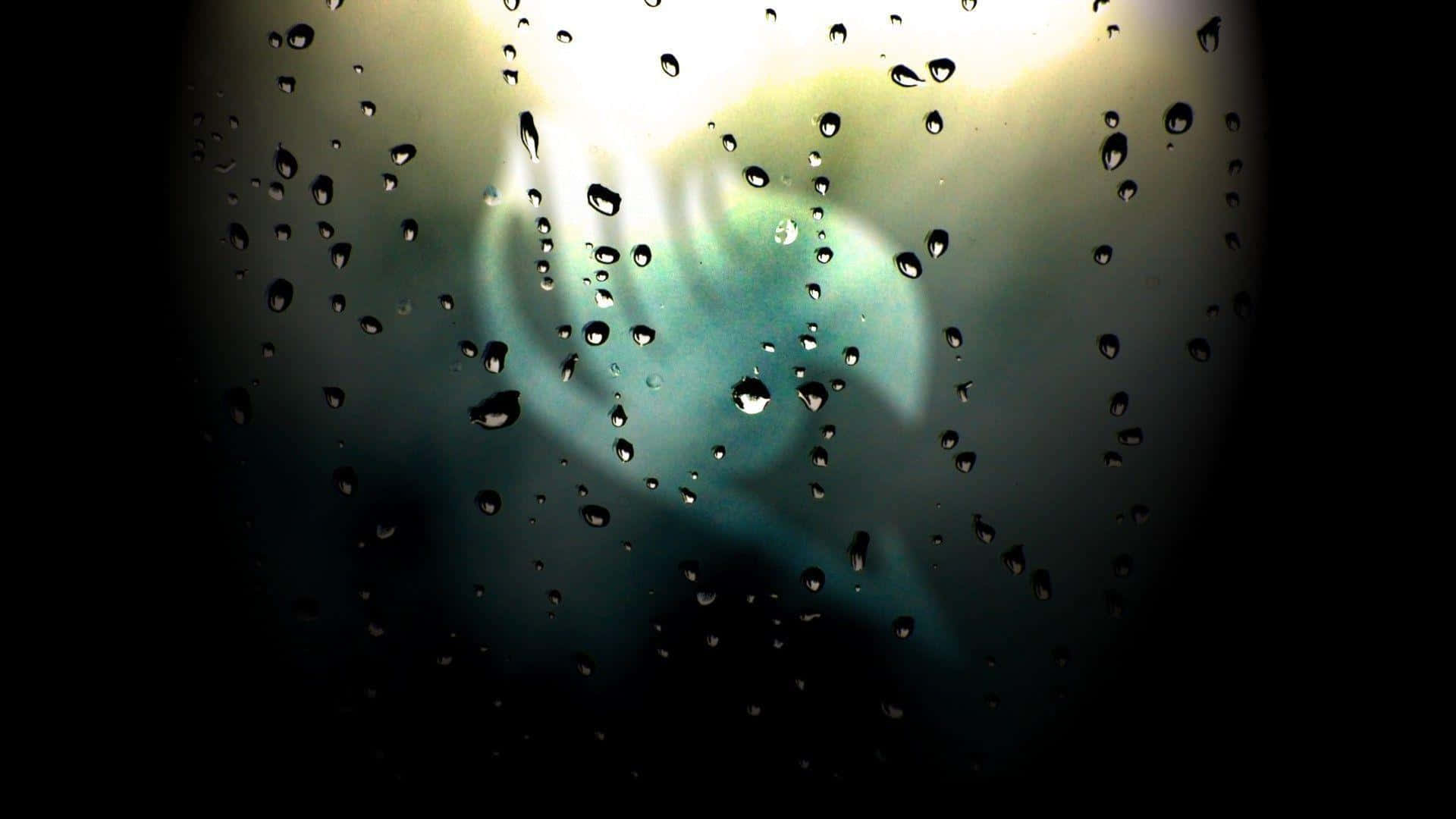 A single drop of rain captured against a bright, azure sky.