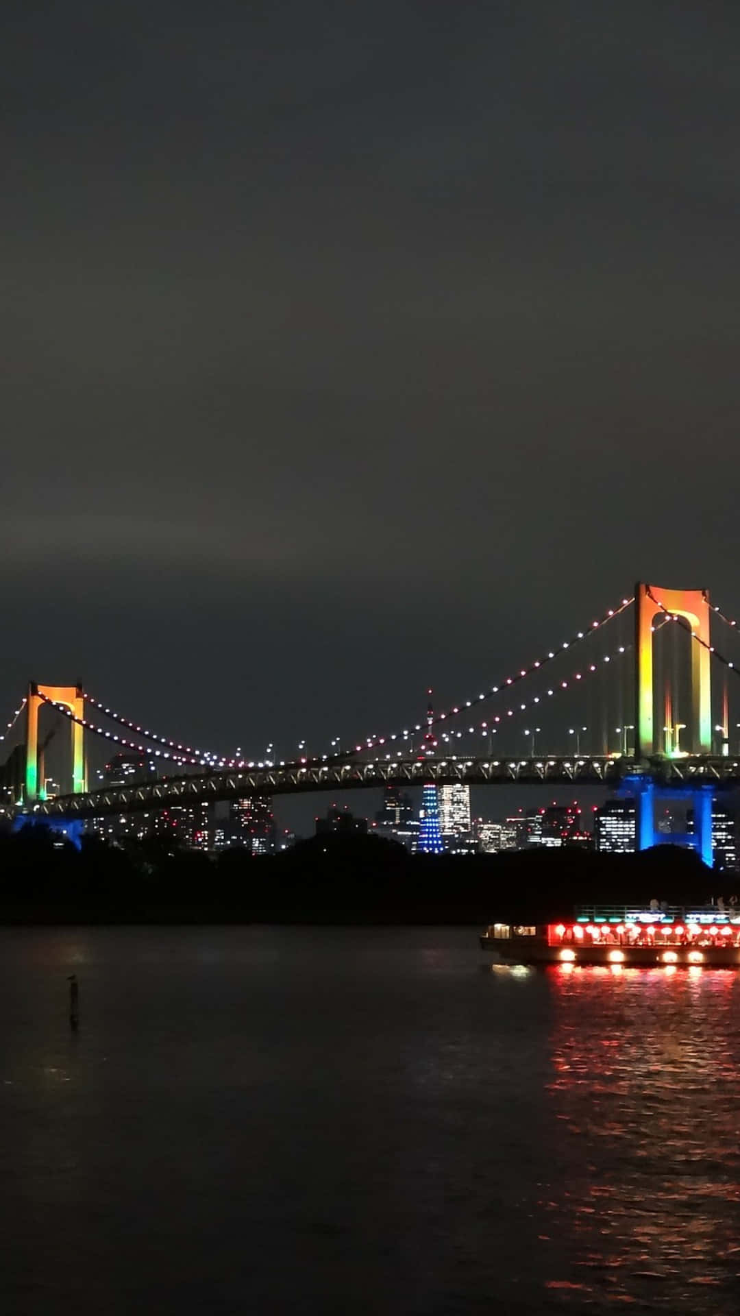A Rainbow Bridge Is Lit Up At Night