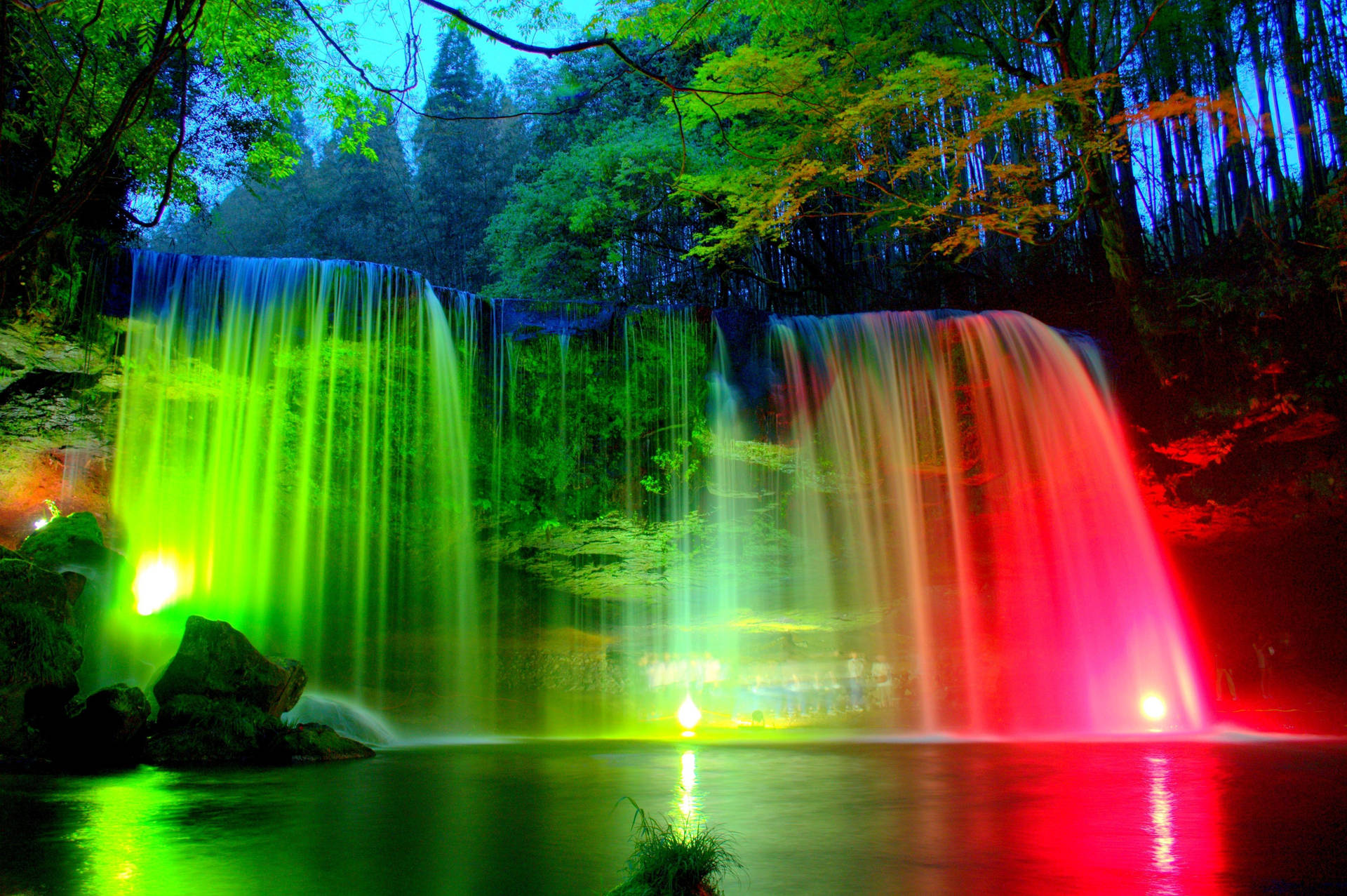 Spectacular rainbow seen through the cascading waters of a majestic waterfall Wallpaper