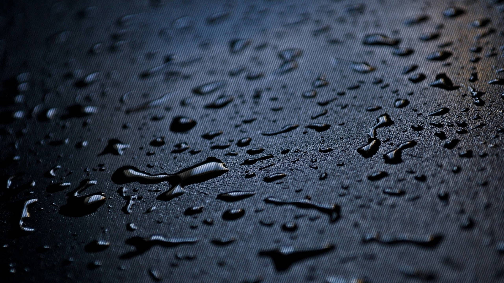 Regndråber og vand splashes på en sort overflade Wallpaper
