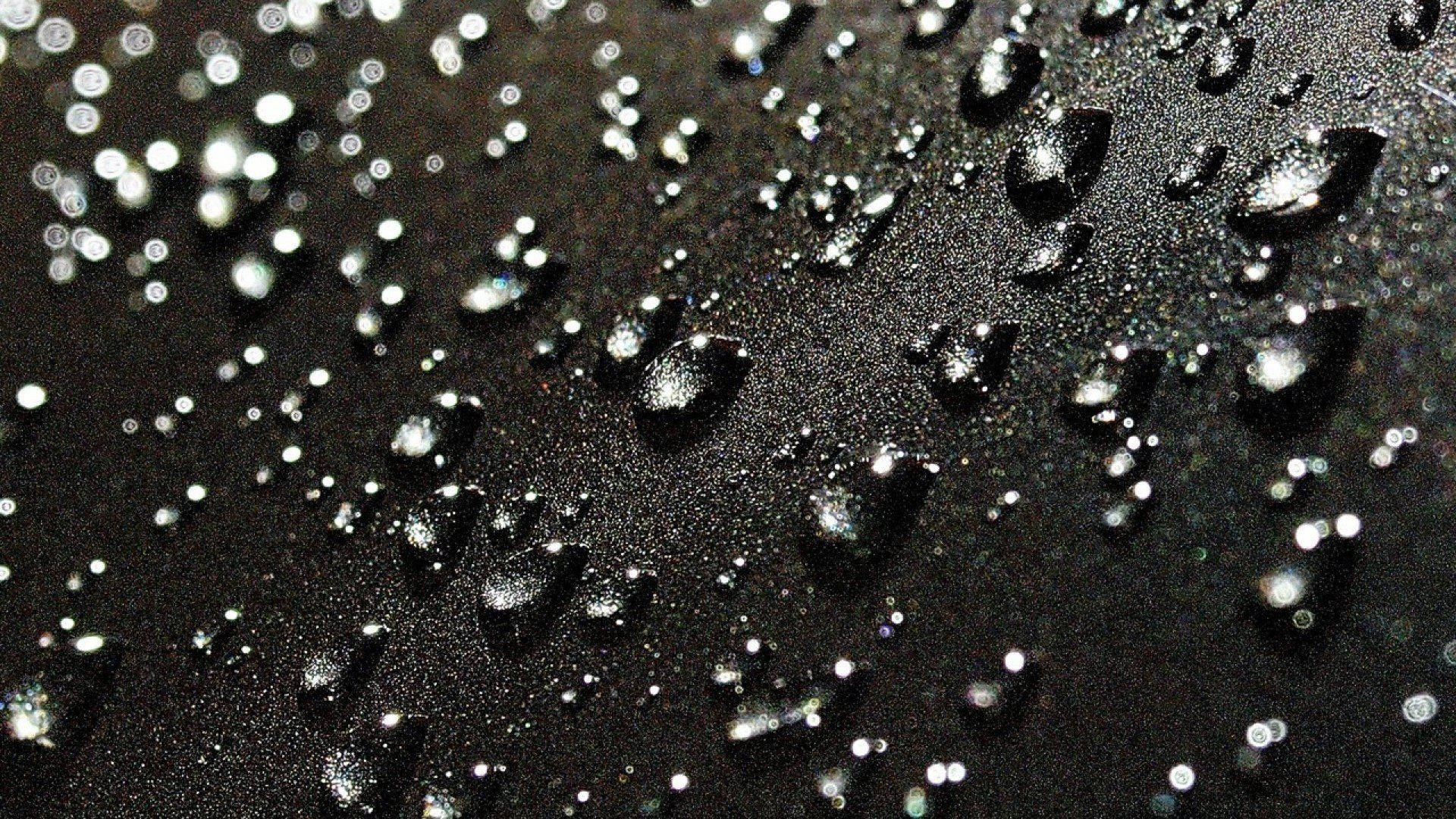 Gotasde Lluvia Cayendo Sobre Una Superficie Negra Profunda. Fondo de pantalla