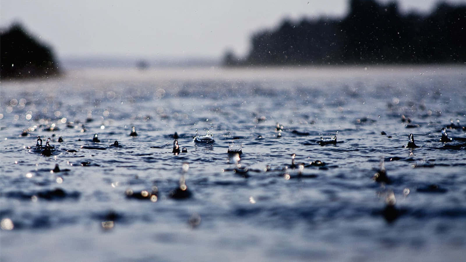 Bildvon Regentropfen Auf Dem Wasser An Einem Regnerischen Tag.
