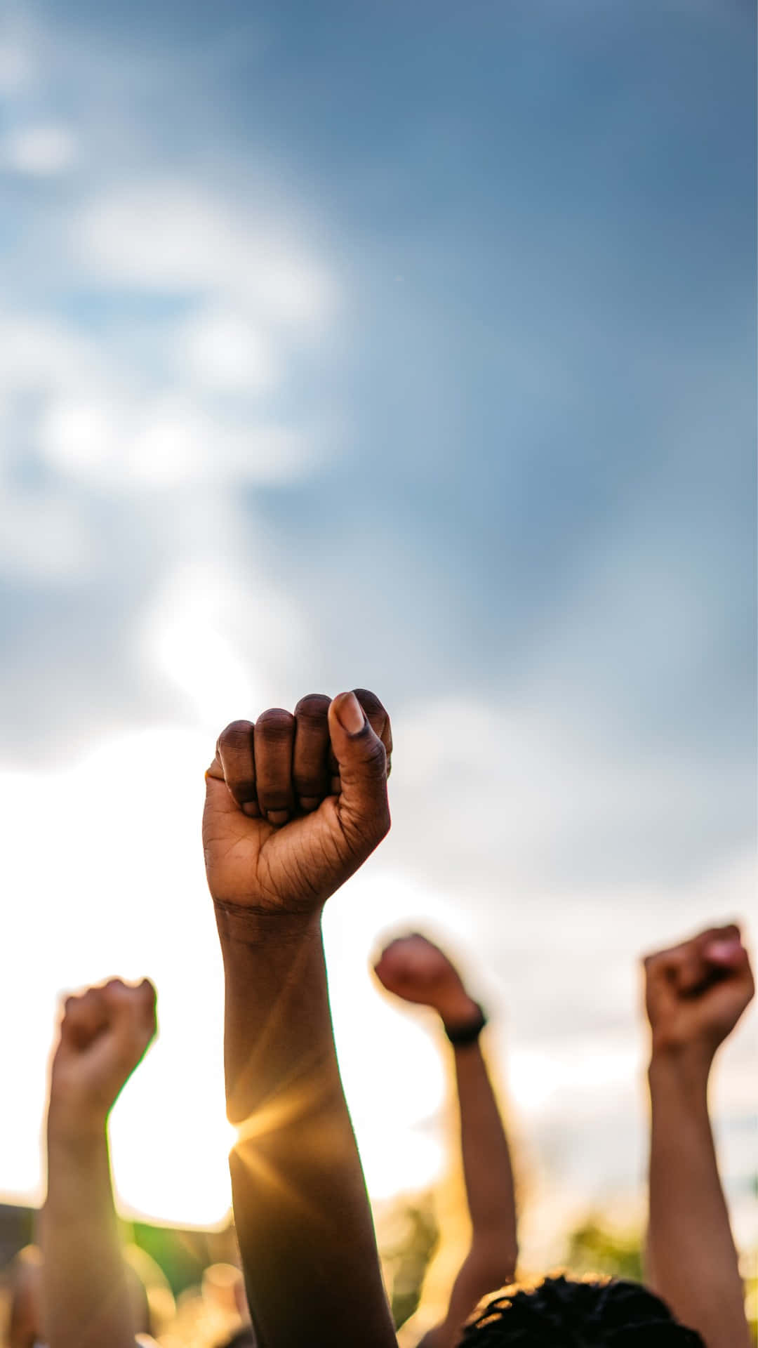 Raised Fists Against Sky Protest Solidarity Wallpaper