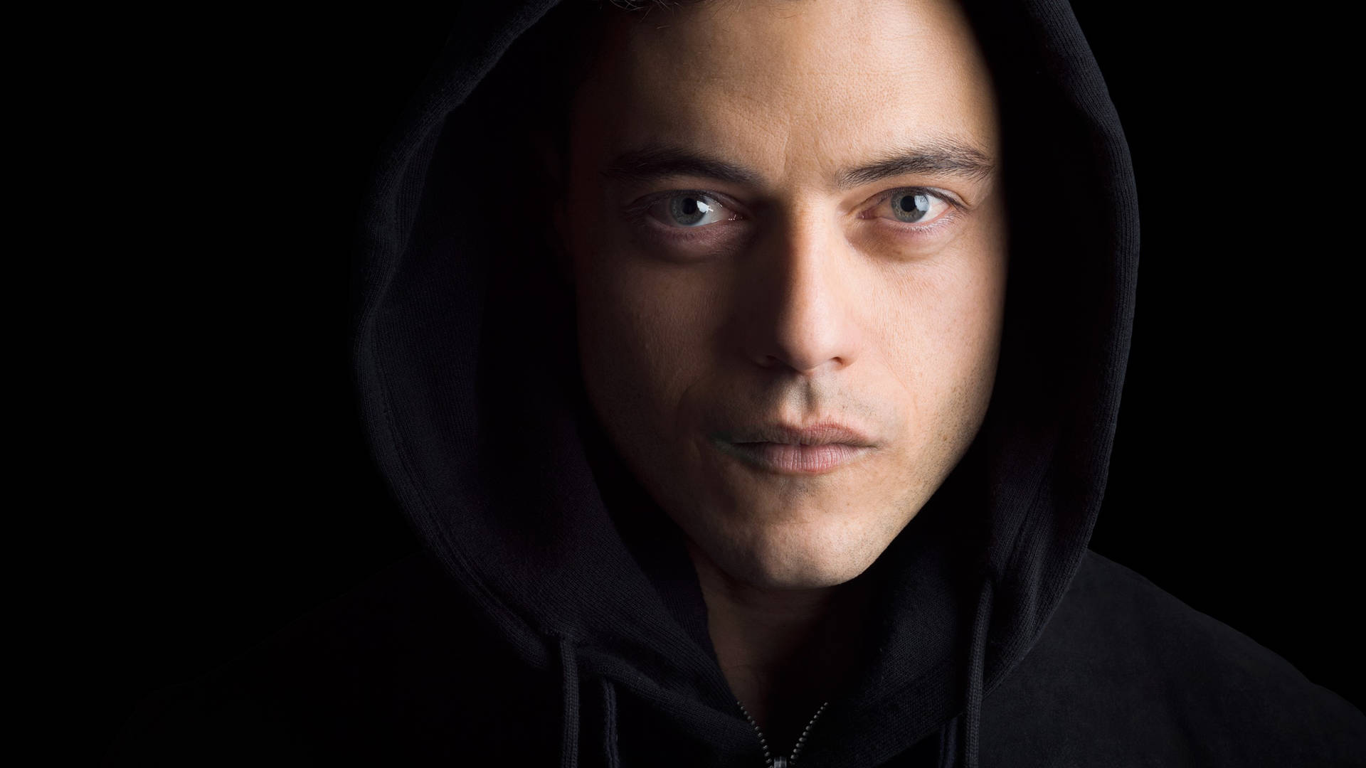 Rami Malek In A Thought-provoking Moment During A Movie Shoot Wallpaper