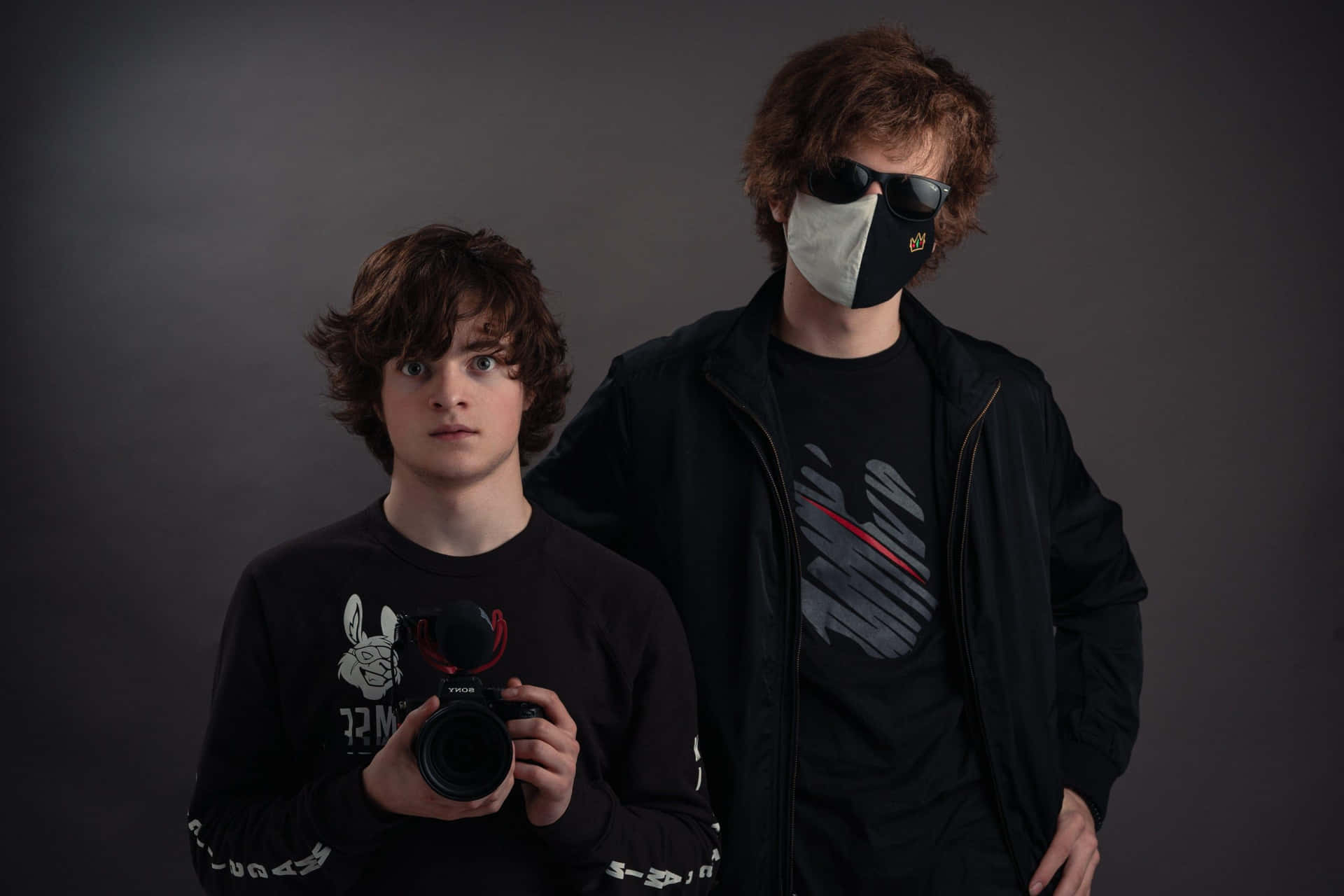 Two Young Men Wearing Masks And Holding Cameras