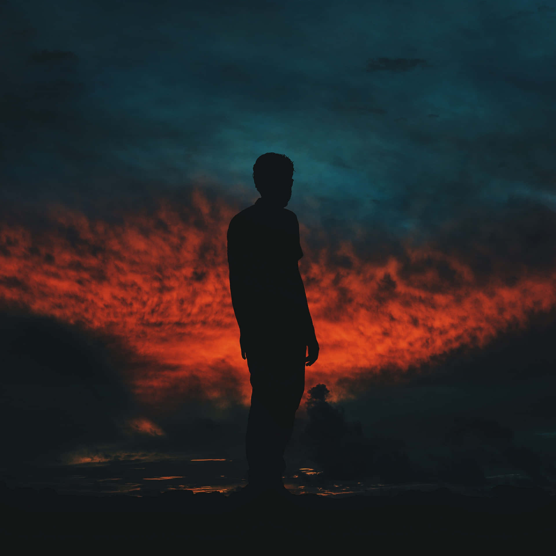 Random Person Silhouette Against Dark Sunset Sky Wallpaper