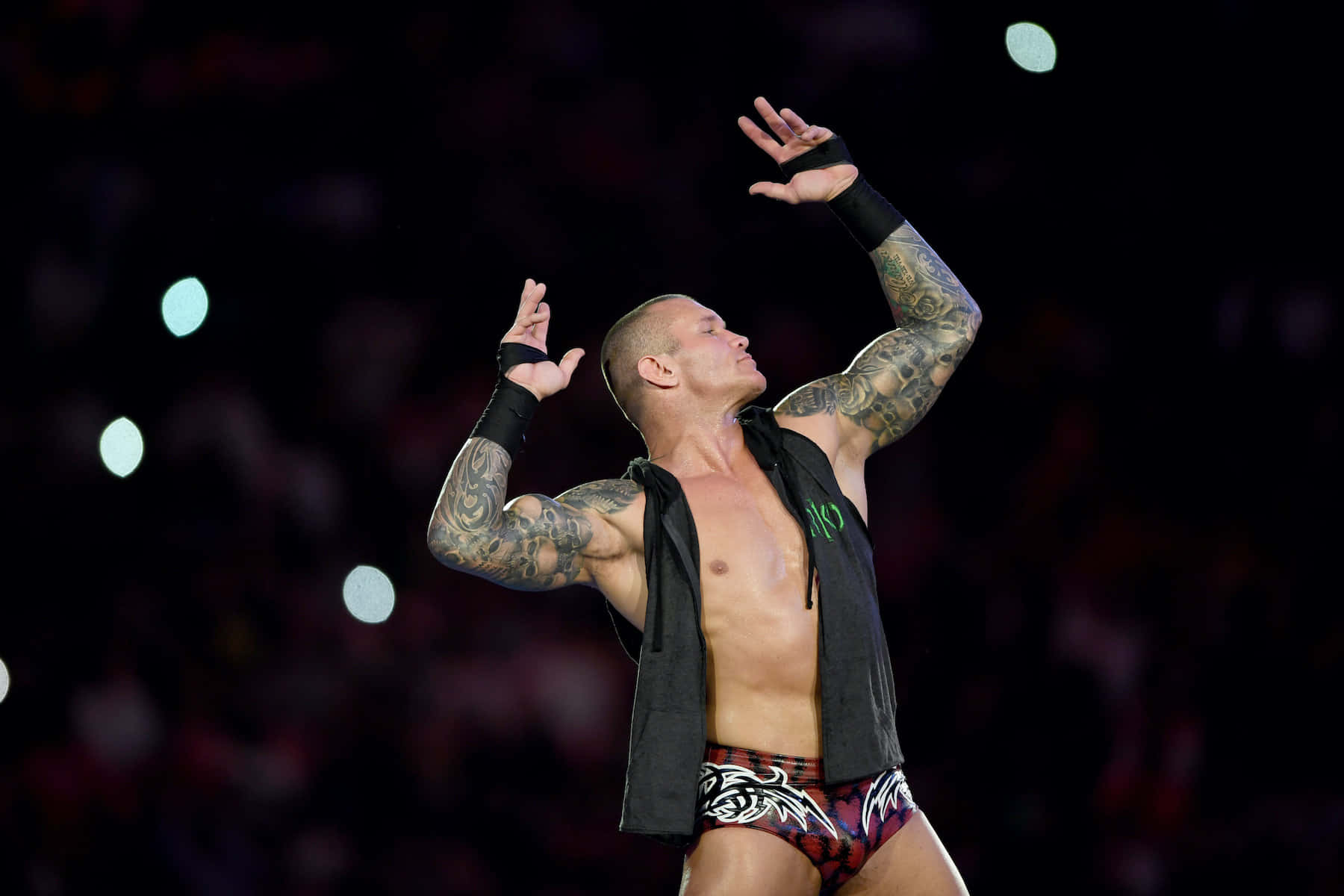 A Wrestler With Tattoos Is Holding His Arms Up Wallpaper