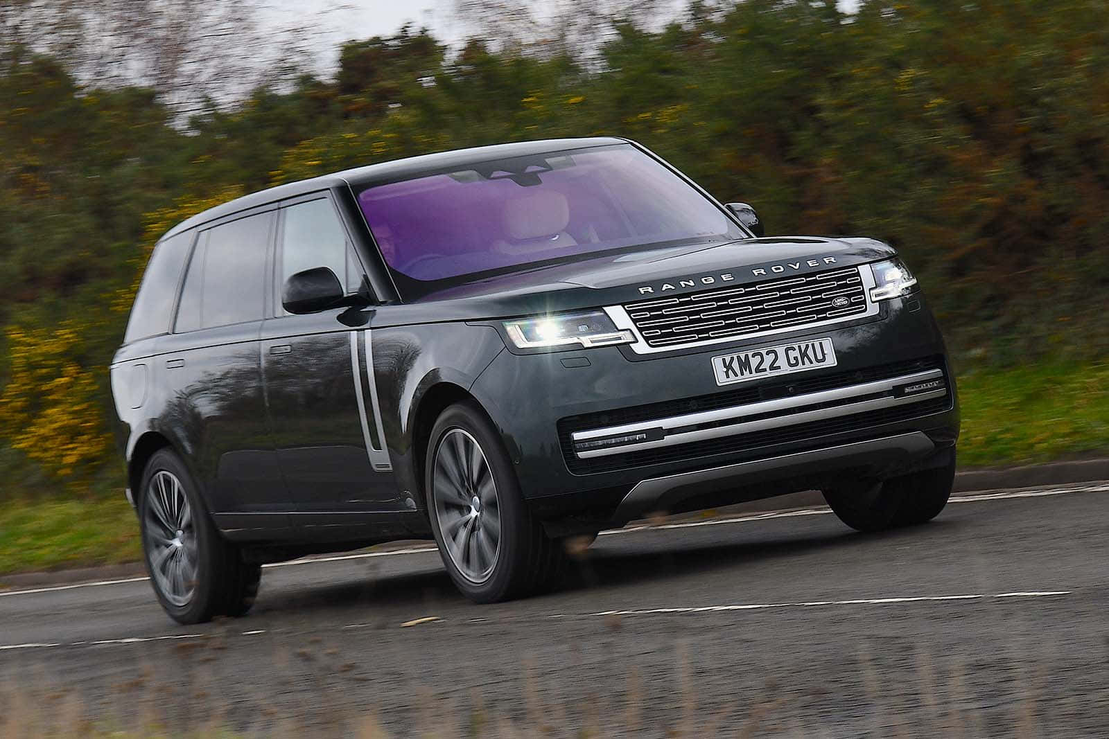The Range Rover Vogue Is Driving Down A Country Road